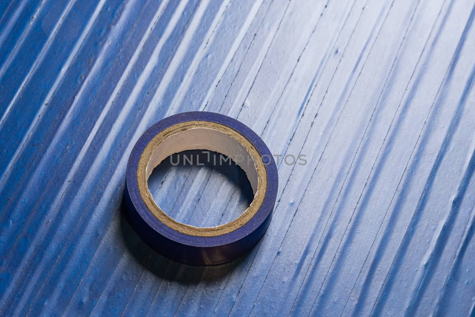 one roll of old blue pvc duct tape on surface covered by same tape