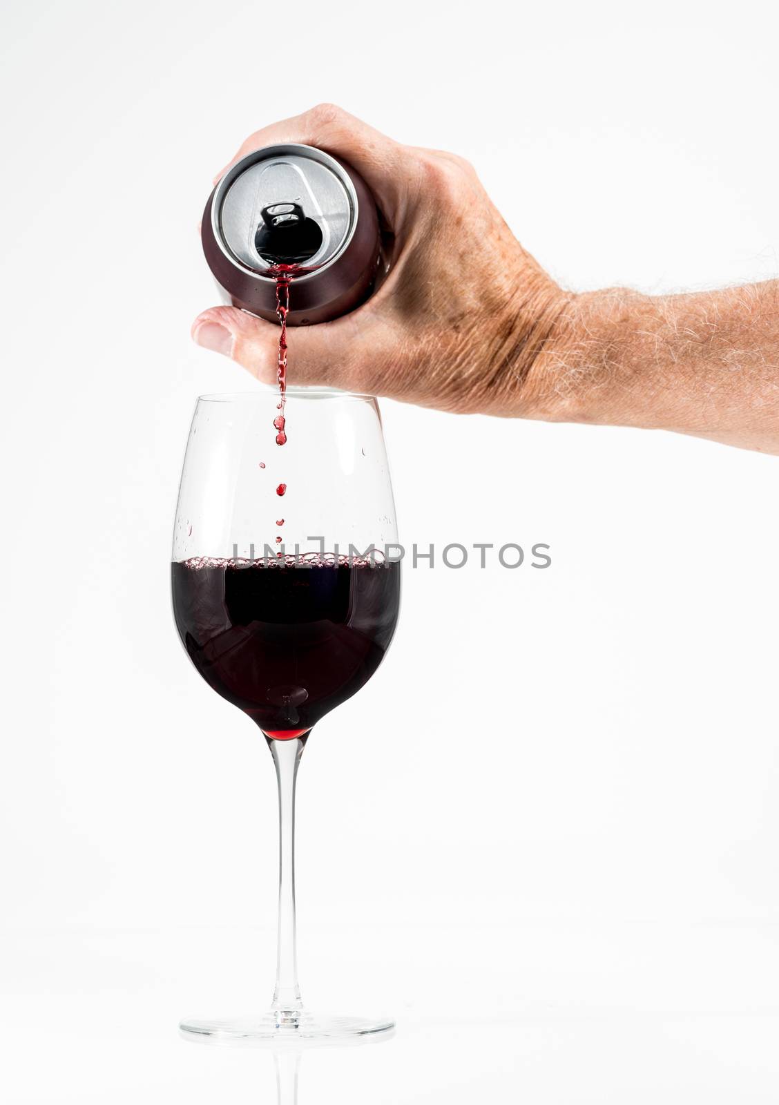 Senior adult pouring a glass of red wine from an aluminum can by steheap