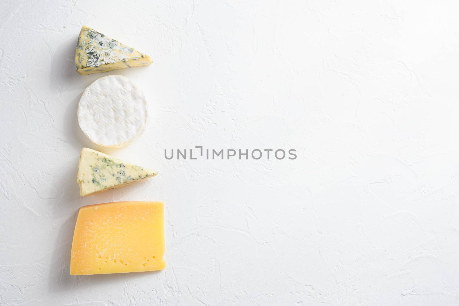 Cheese platter: yellow Maasdam, white Camembert and blue cheese Dor Blue on white background. Copy space. Concept serving cheese. Top view text space for you.