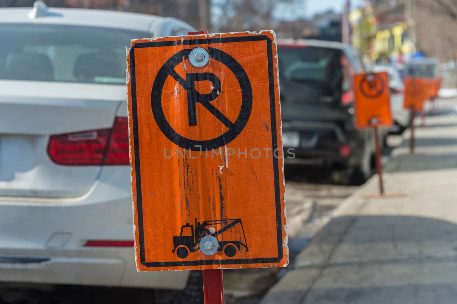 No parking signs next to parked cars in Montreal