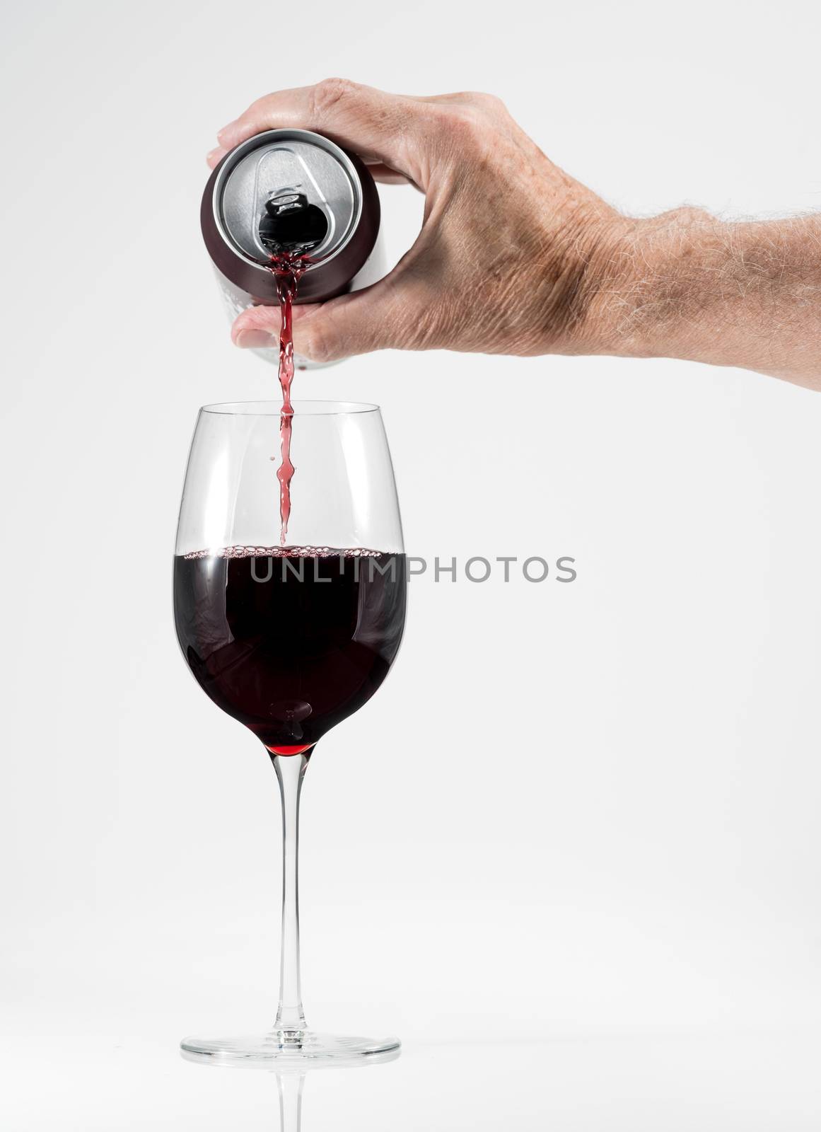 Senior man hand pouring a glass of red wine from a single serving can