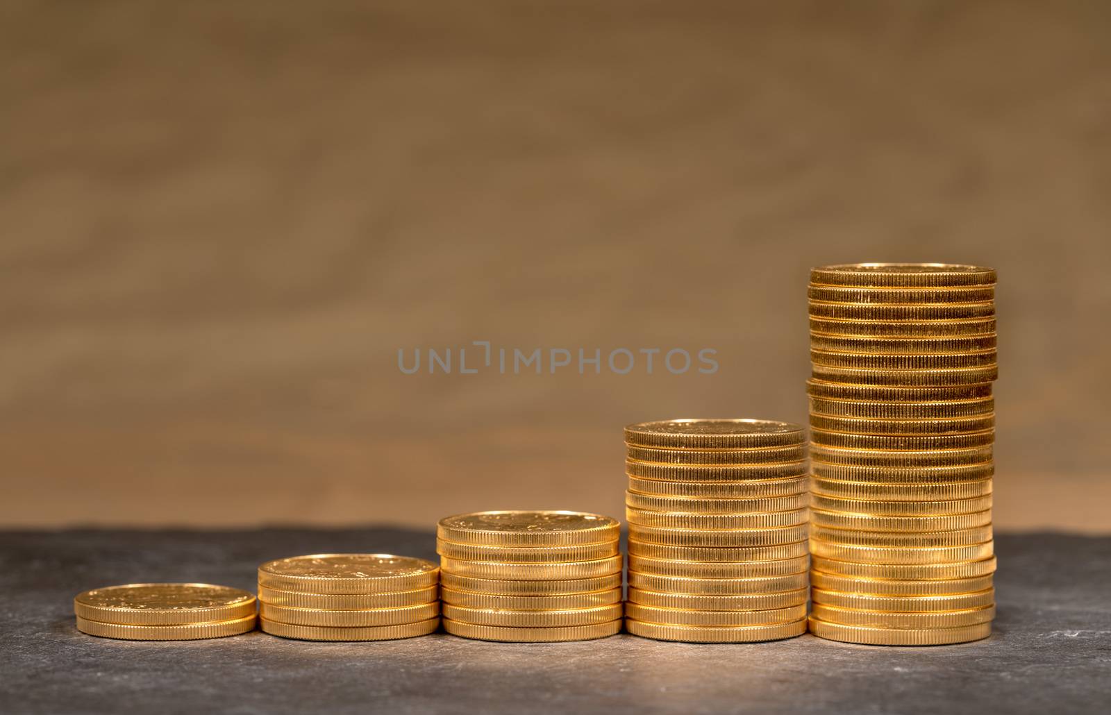 Concept illustration of growth of price of gold with stacks of gold eagle US Treasury golden coins