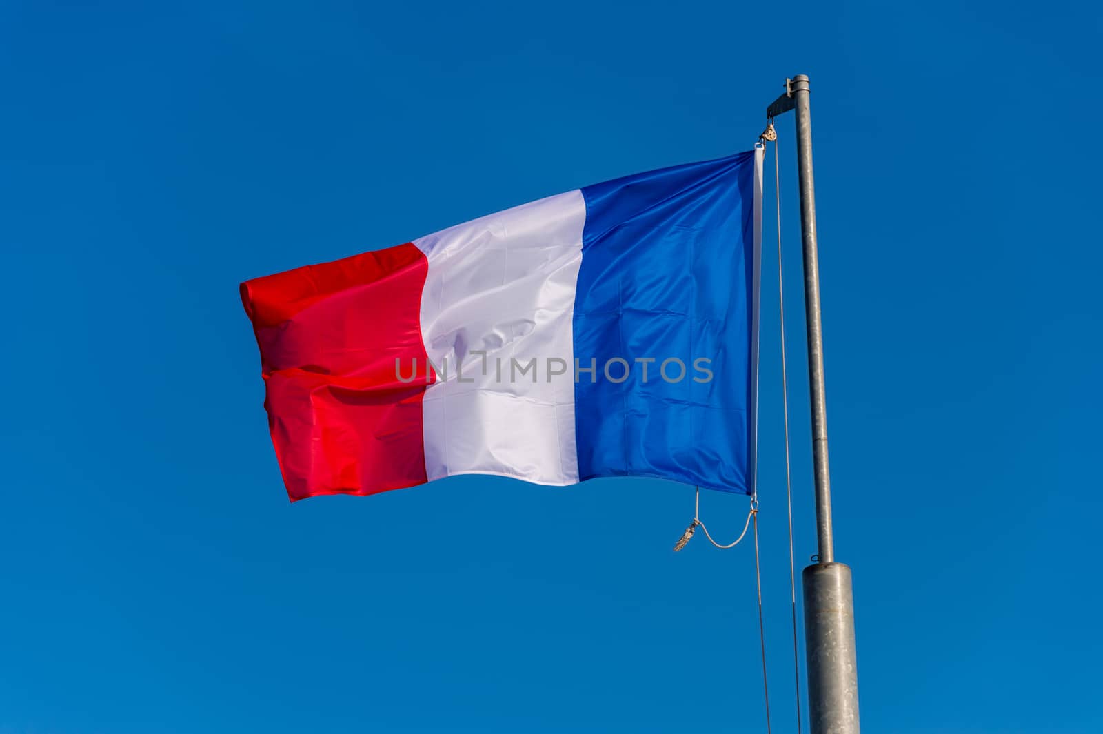 French flag waving against blue sky in Boulogne sur Mer, France. by mbruxelle