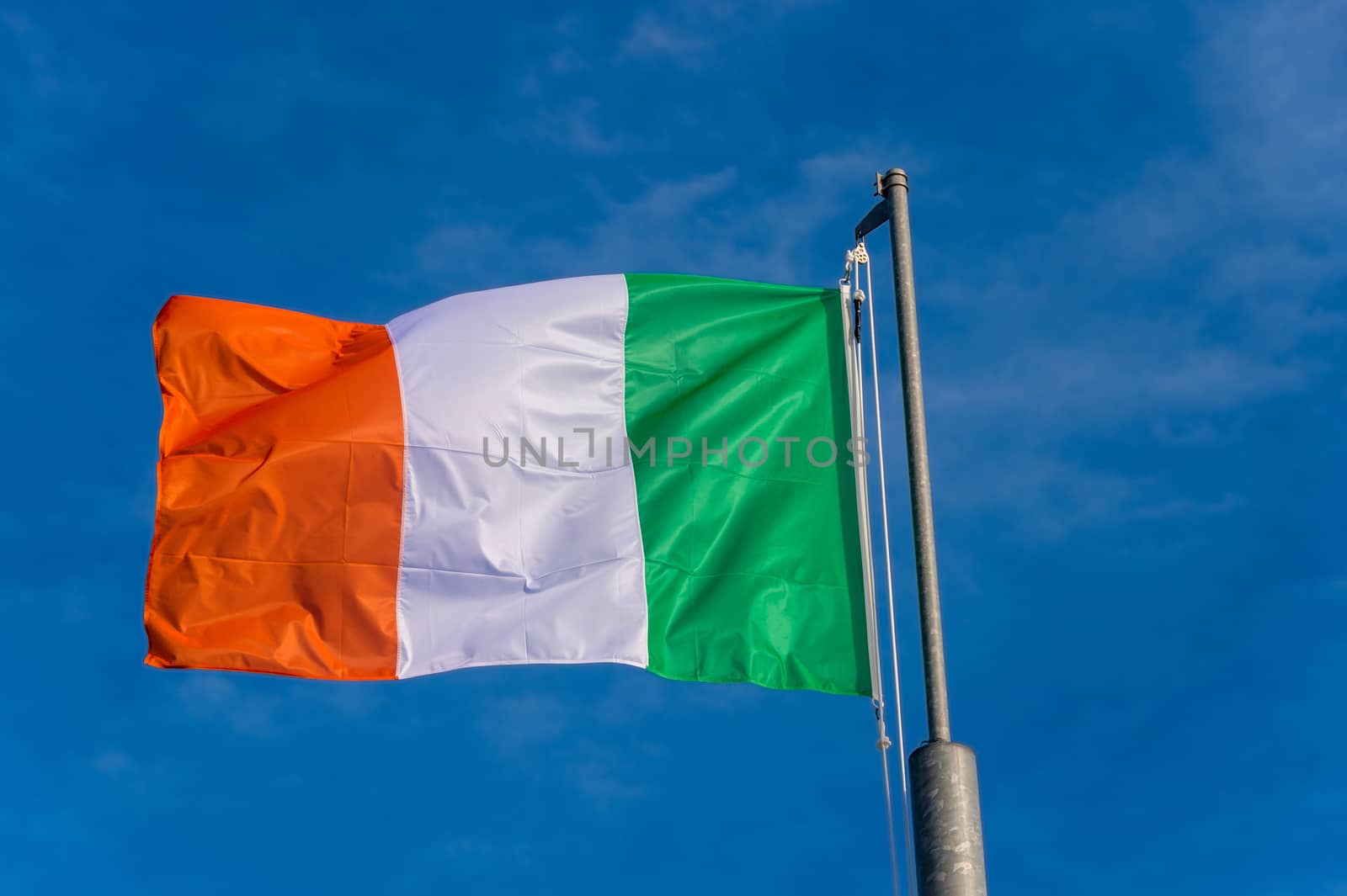 Italian flag waving against blue sky in Boulogne sur Mer, France.