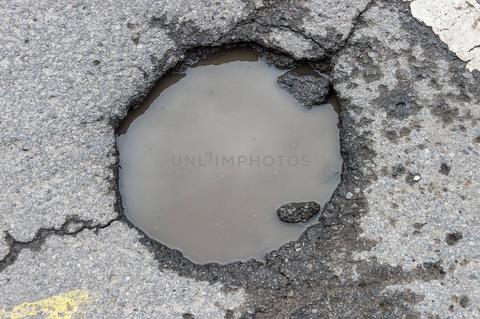 Large rounded pothole filled with water in Montreal by mbruxelle