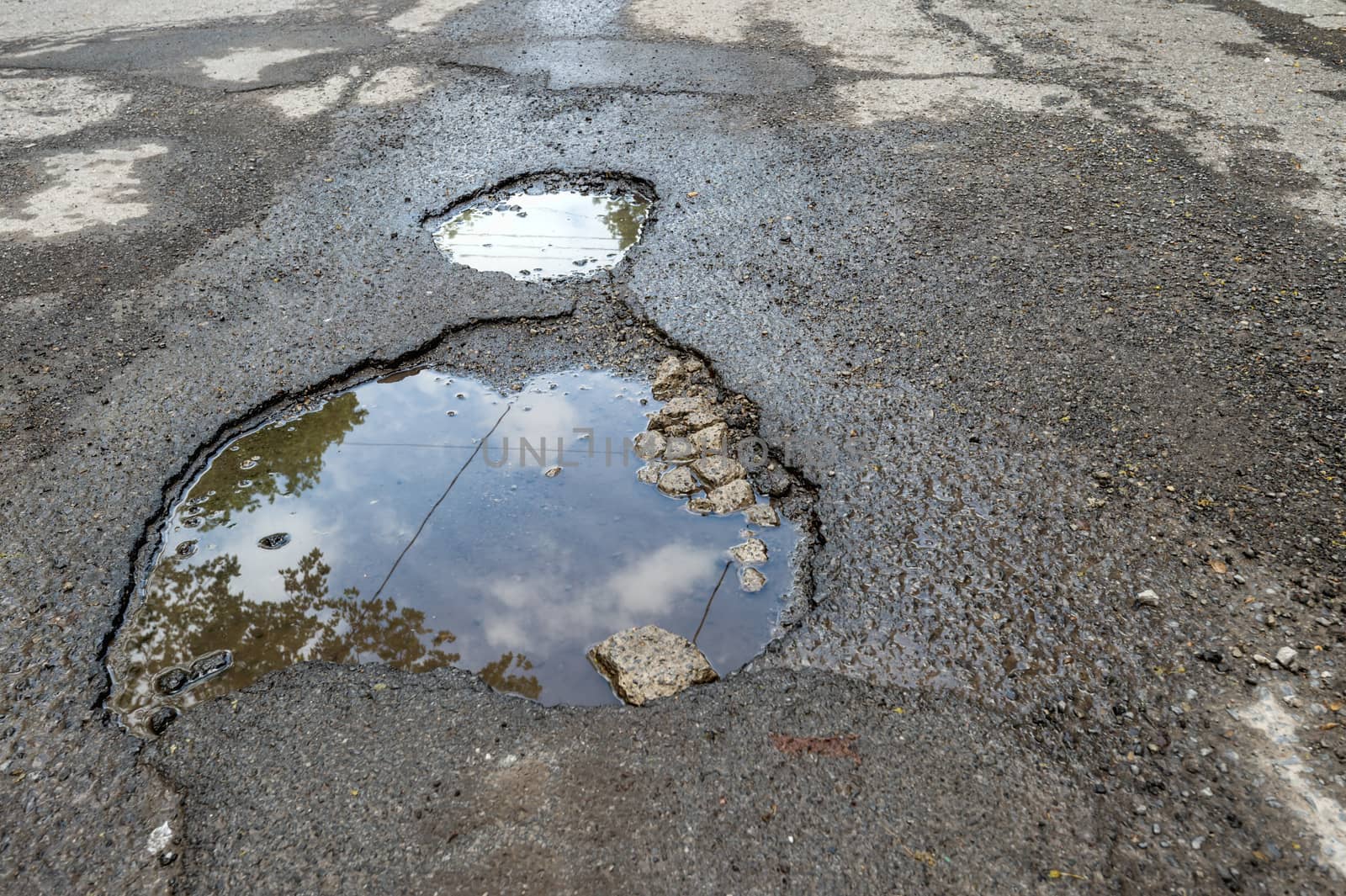Large rounded pothole filled with water in Montreal