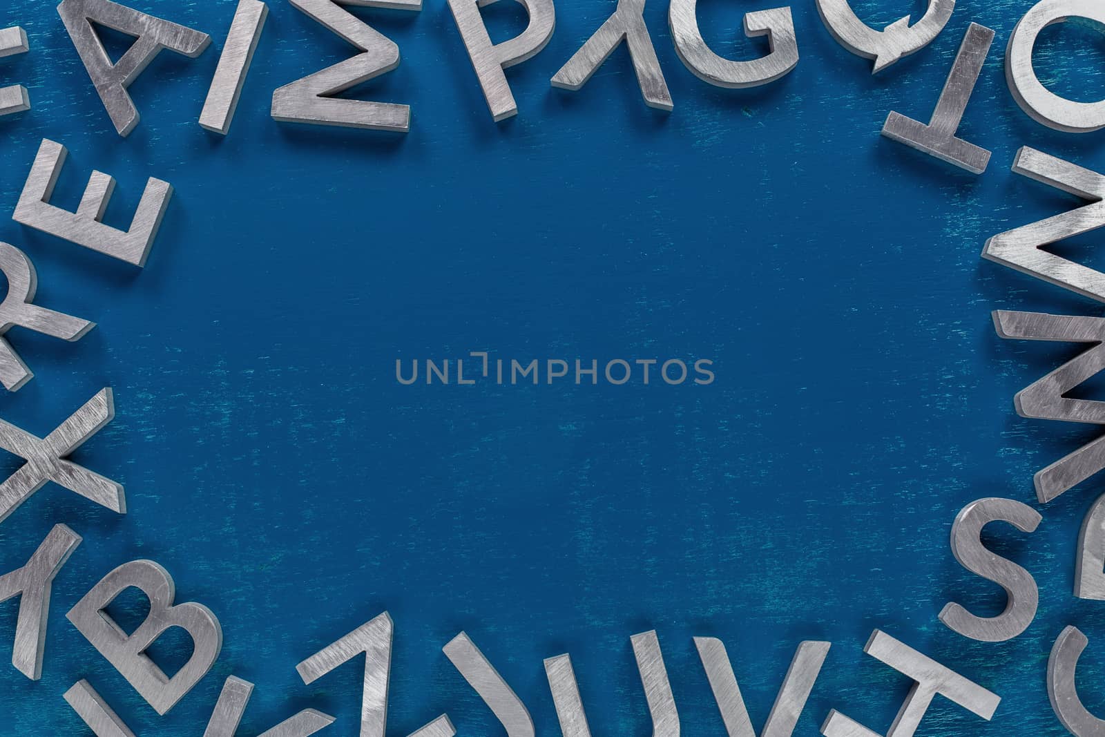 Frame mockup made of of silver metal english alphabet characters on classic blue background. by z1b