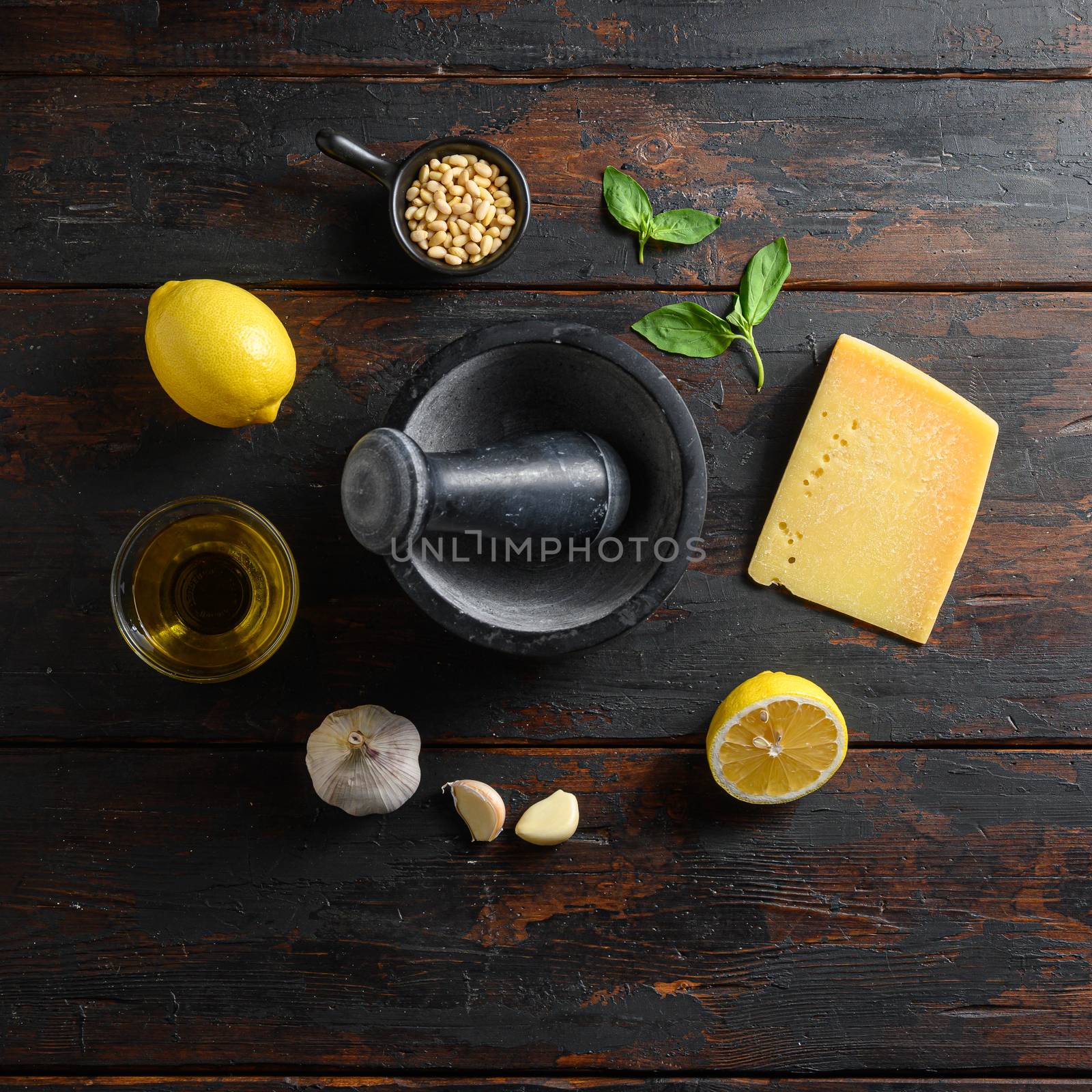 ingredients for pesto over wood planks background Parmesan cheese, basil leaves, pine nuts, olive oil, garlic mortar top view space for text square by Ilianesolenyi