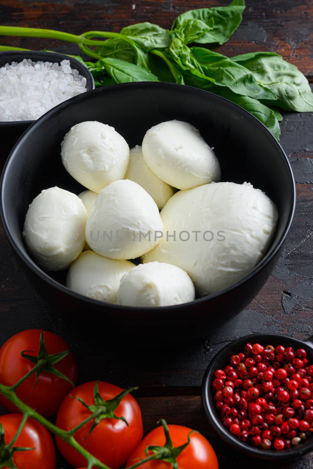 italian cuisine . Ingredients for caprese Fresh cherry tomatoes, cherry mozzarella, fresh basil on wood rustic table background by Ilianesolenyi