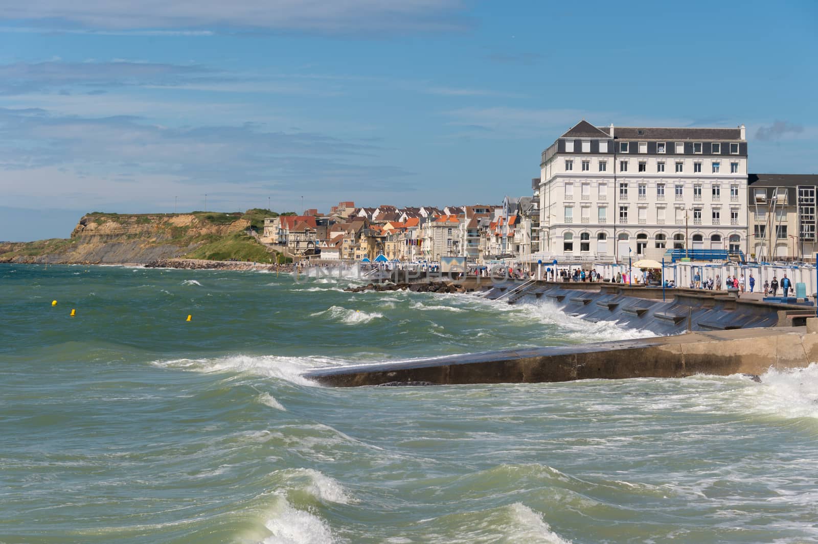 Wimereux, France - 16 June 2018: View of the sea front promenade as waves are hitting the seawall.