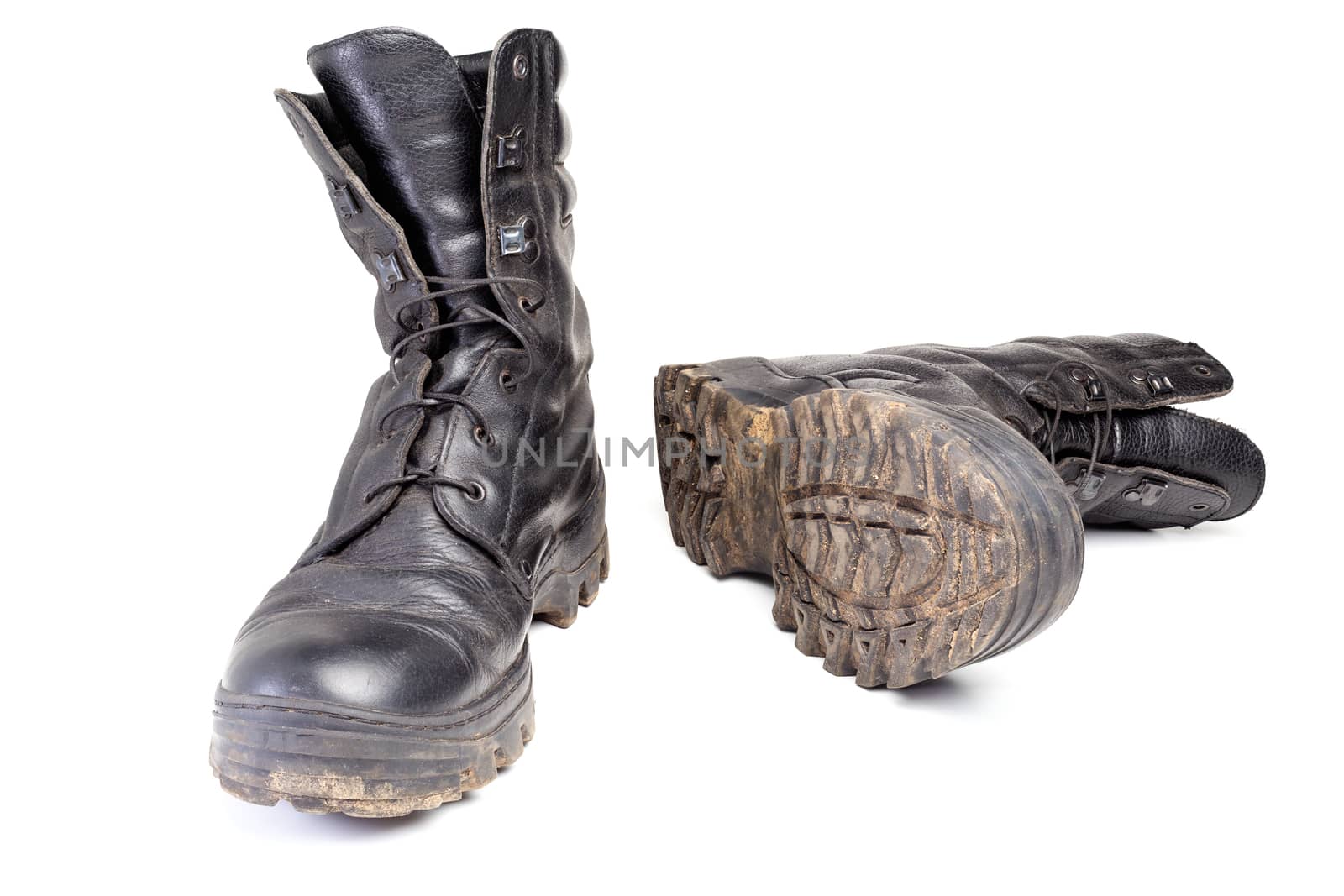 pair of used dirty and dusty military black boots isolated on white background with natural soft shadows