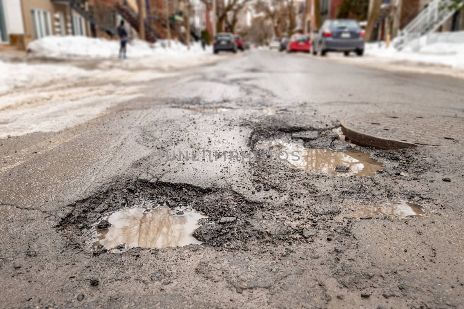 Large potholes in Montreal street, in Winter