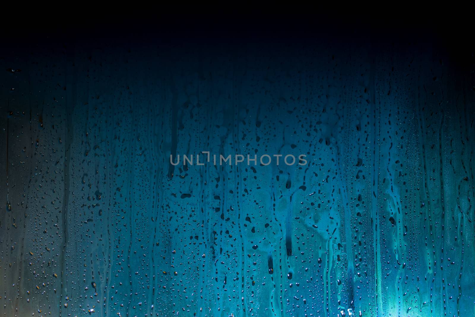 dark cyan-blue to black gradient background of night wet glass with water drops and smudges.