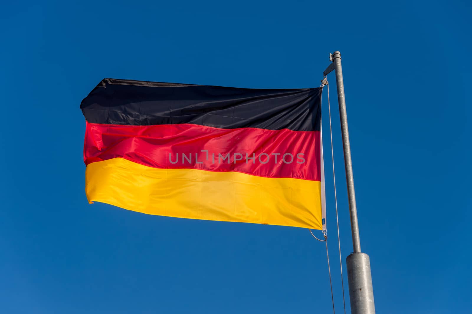German flag waving against blue sky in Boulogne sur Mer, France.