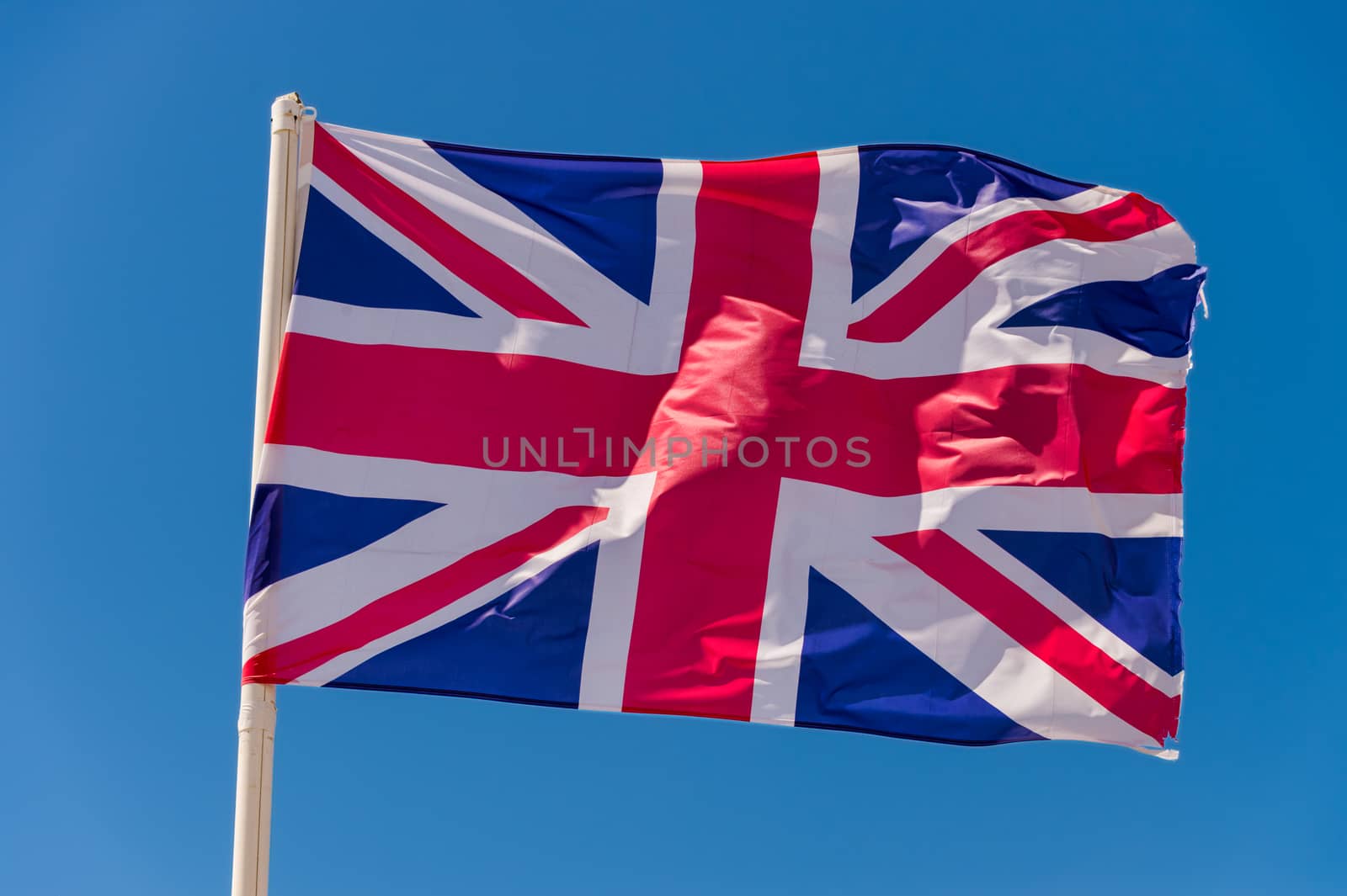 British flag waving against blue sky in Wimereux, France.