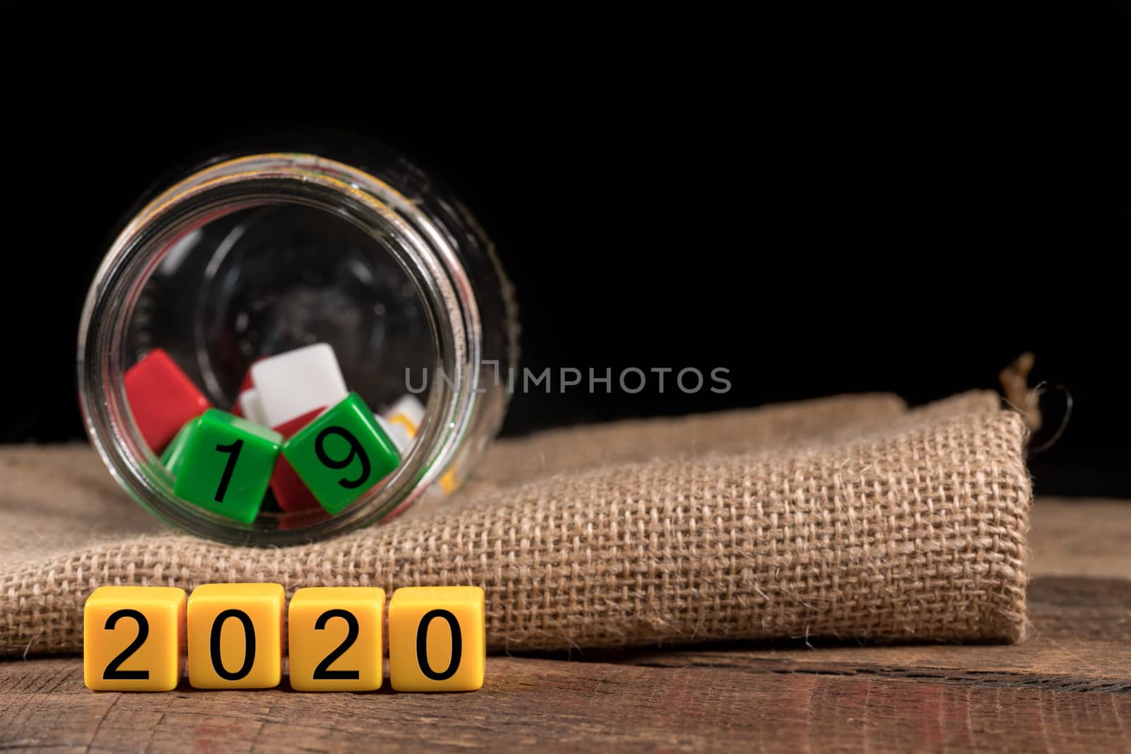 2019 being put back in the jar as dice for 2020 is spread on wooden table for New Years celebrations