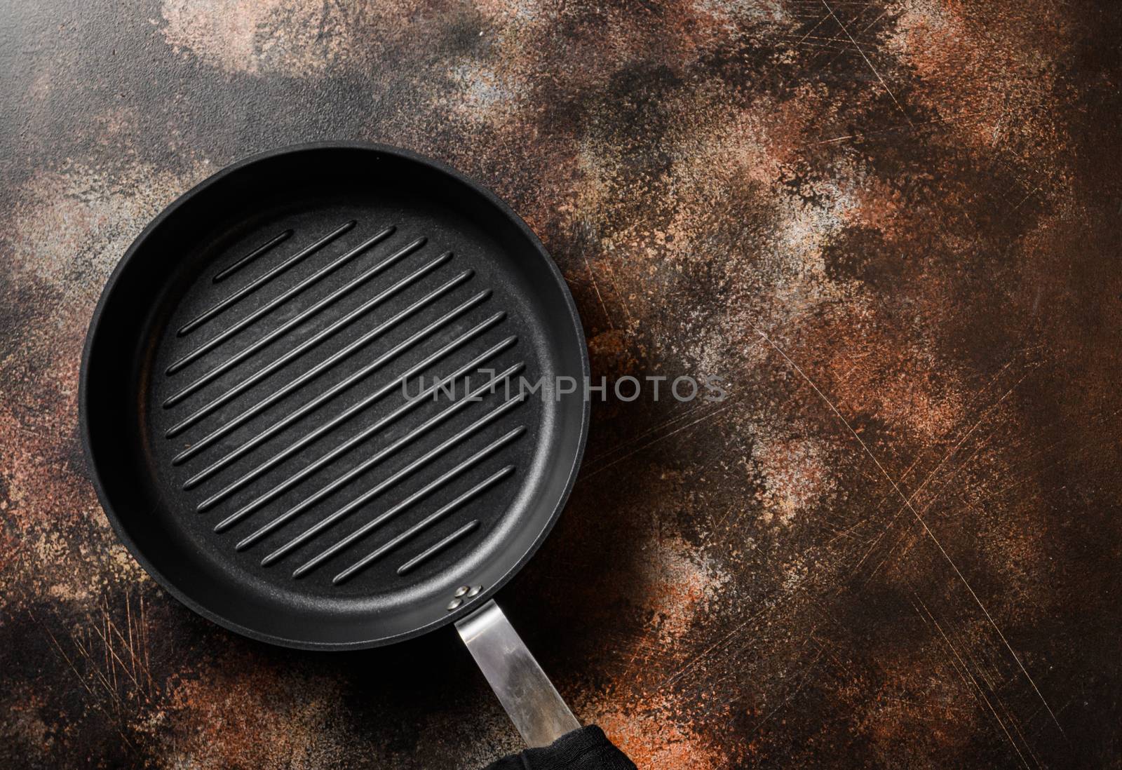 empty cast-iron grill pan and linen cloth on metal rustic table top view space for text