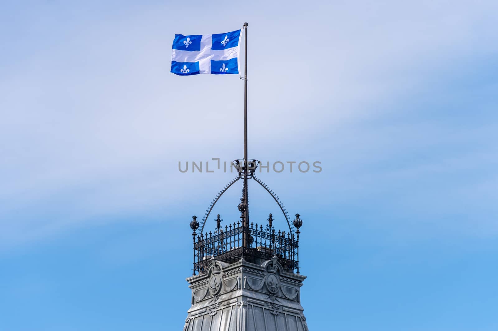 Quebec Flag waving in the wind against blue sky in Quebec City.