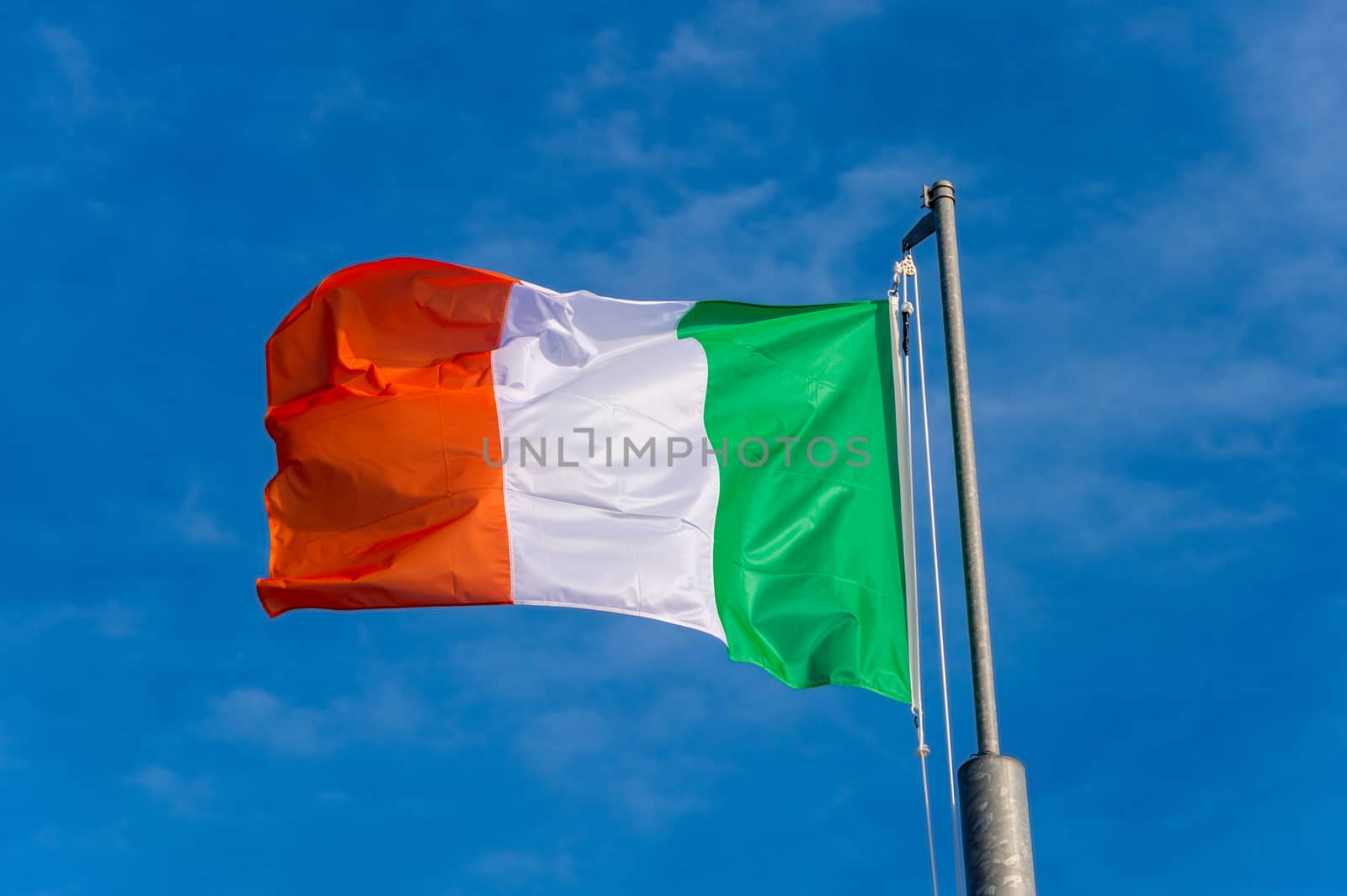 Italian flag waving against blue sky in Boulogne sur Mer, France.