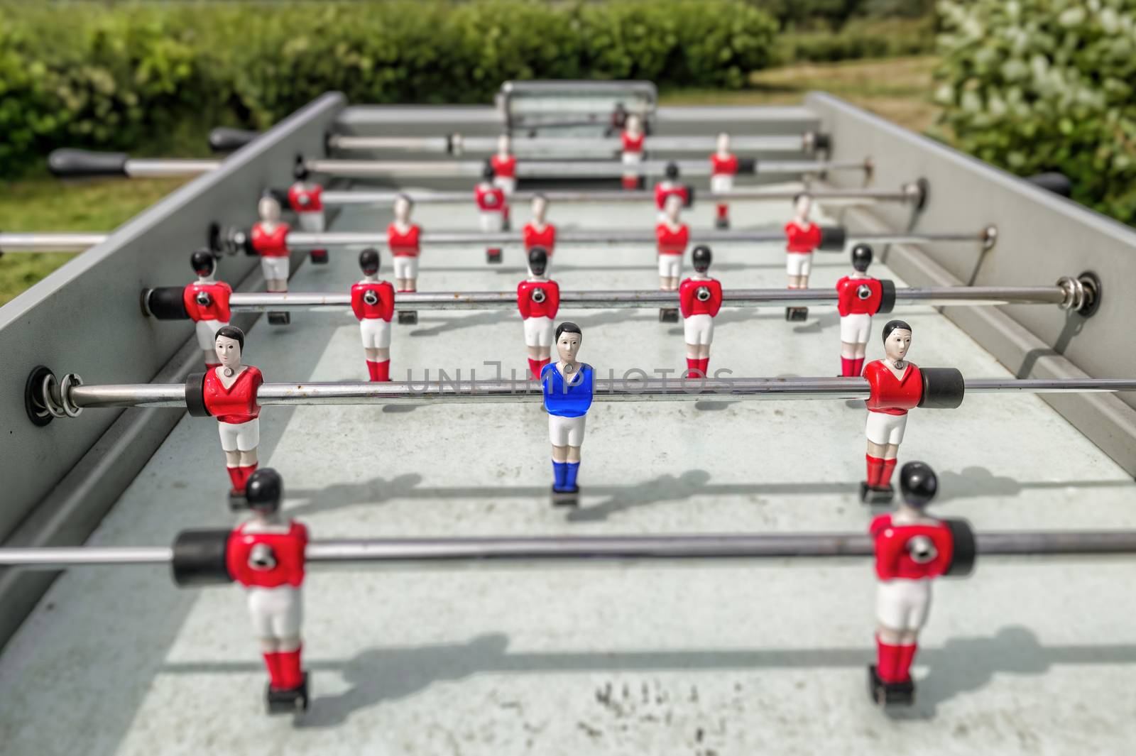 Outdoor table football showing only one blue player. Conceptual image for uniqueness and individuality.
