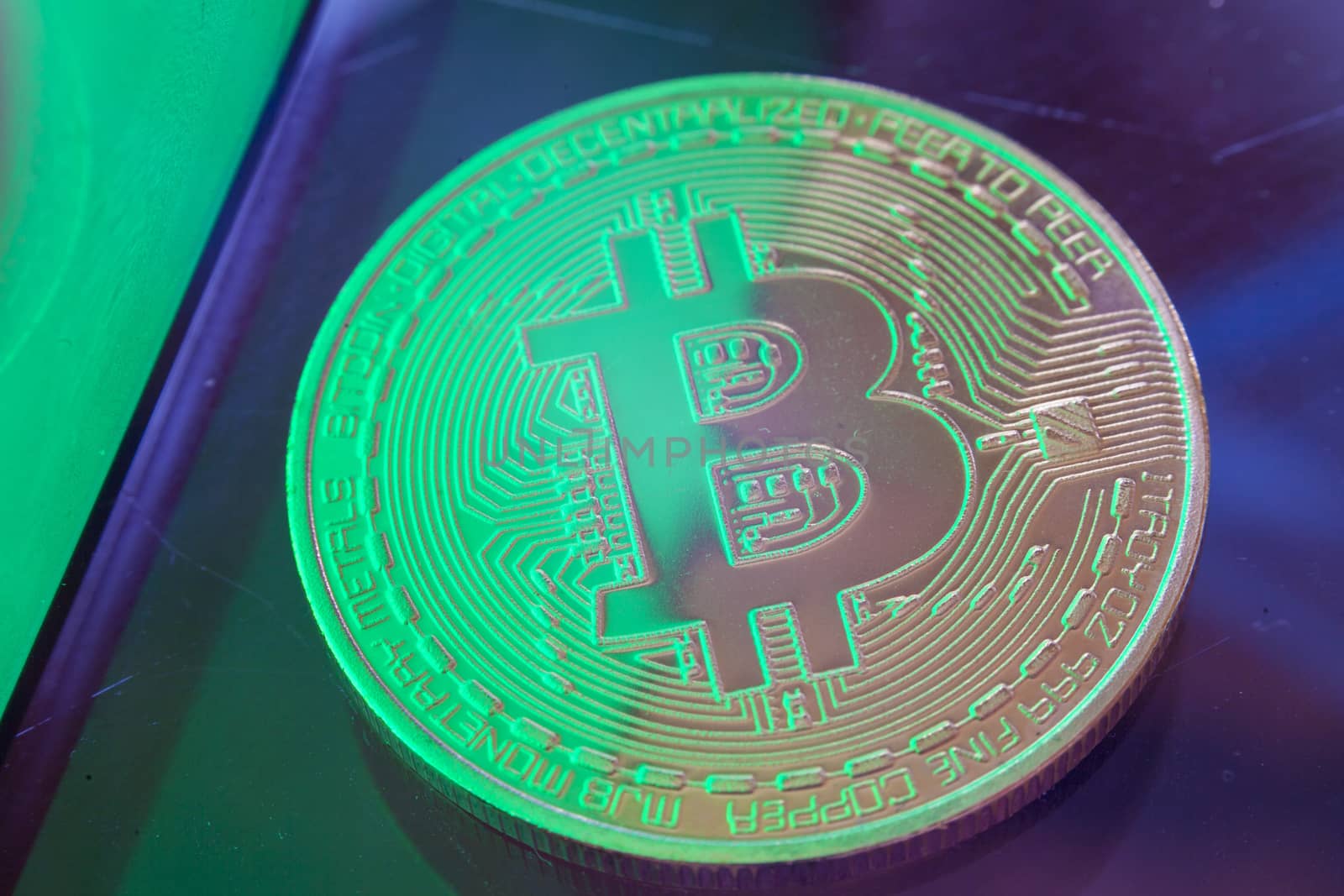 Green light on Bitcoin currency coin extreme close-up by adamr