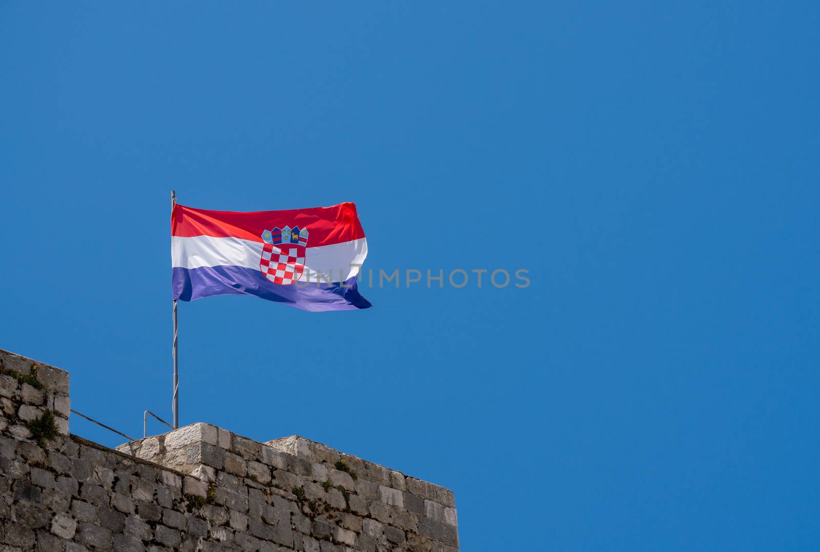 Flag of Croatia or the Tricolour flies on the stone walls of Dubrovnik