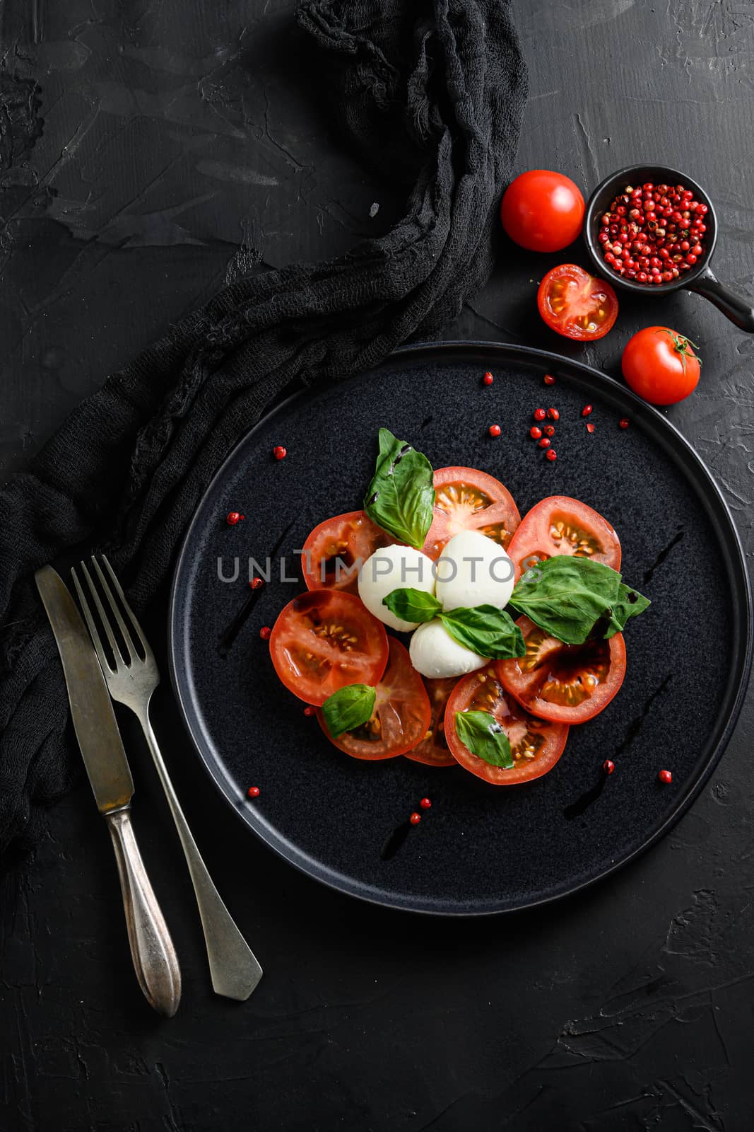 Tomato, basil, mozzarella Caprese salad with balsamic vinegar and olive oil. Top view, blkack stone background overhead by Ilianesolenyi