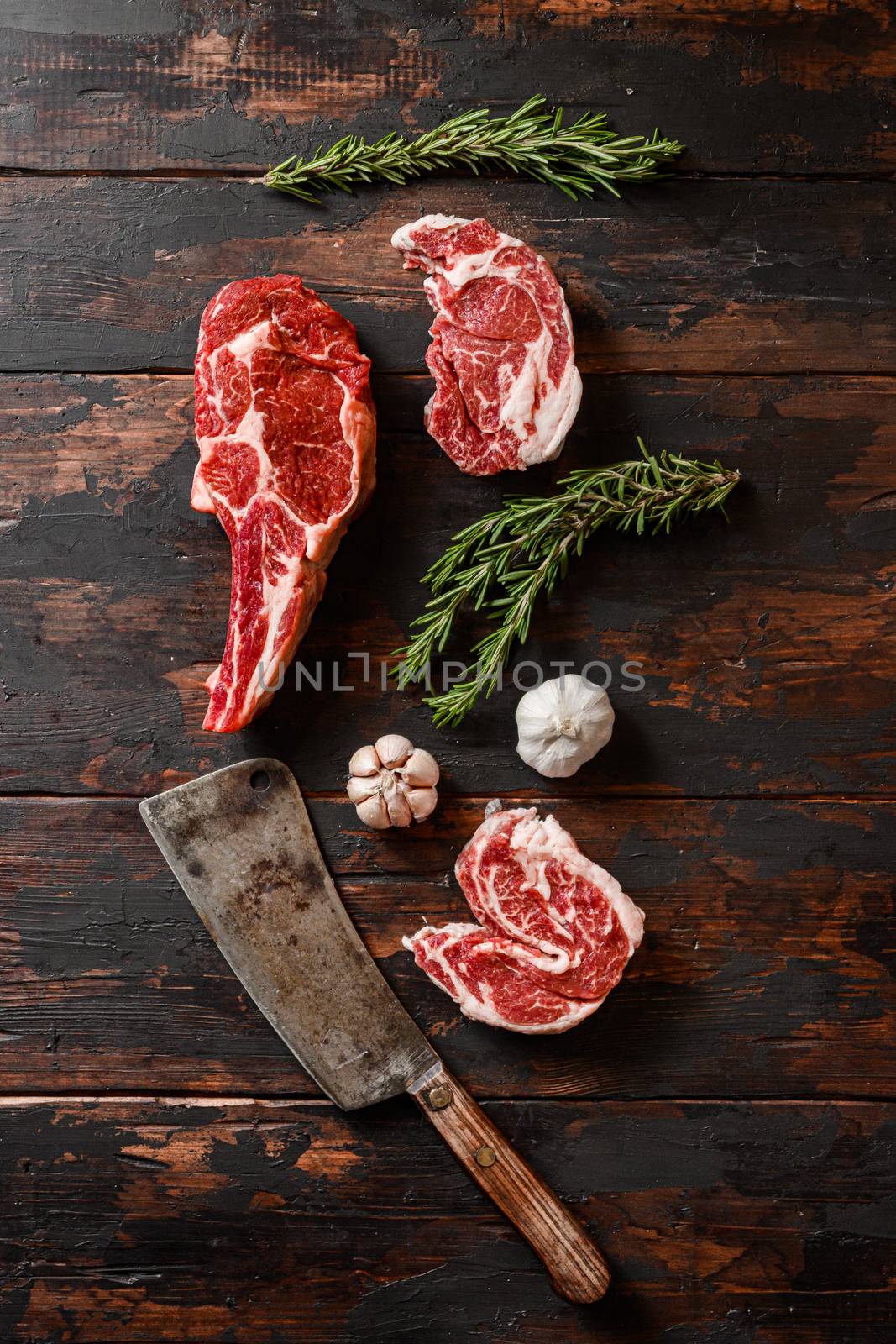 Raw mix various Cowboy steak beef steak, which lies near the cutting knife. Raw beef meat prepared for cooking steaks. Beside the ingredients for cooking steaks, spices and herbs. by Ilianesolenyi