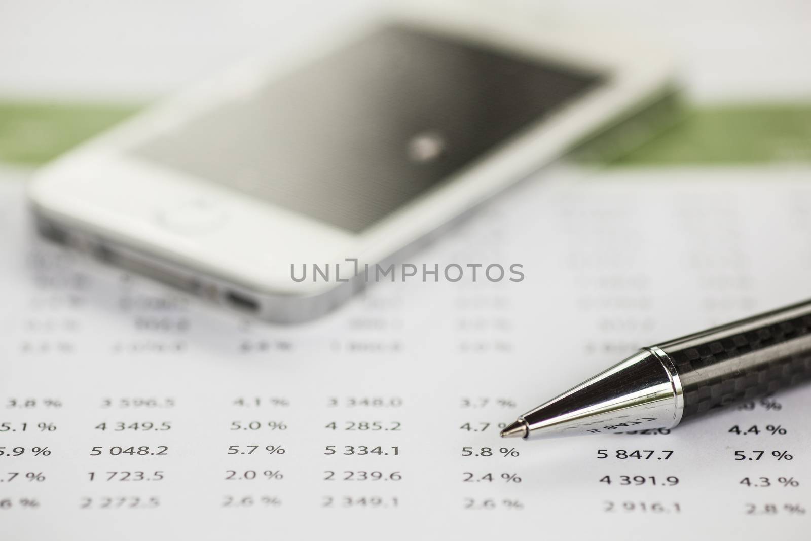 Business analysis - Accounting Calculating Cost Economic on office table. Pencil, chart on papper and bllured smartphone in background