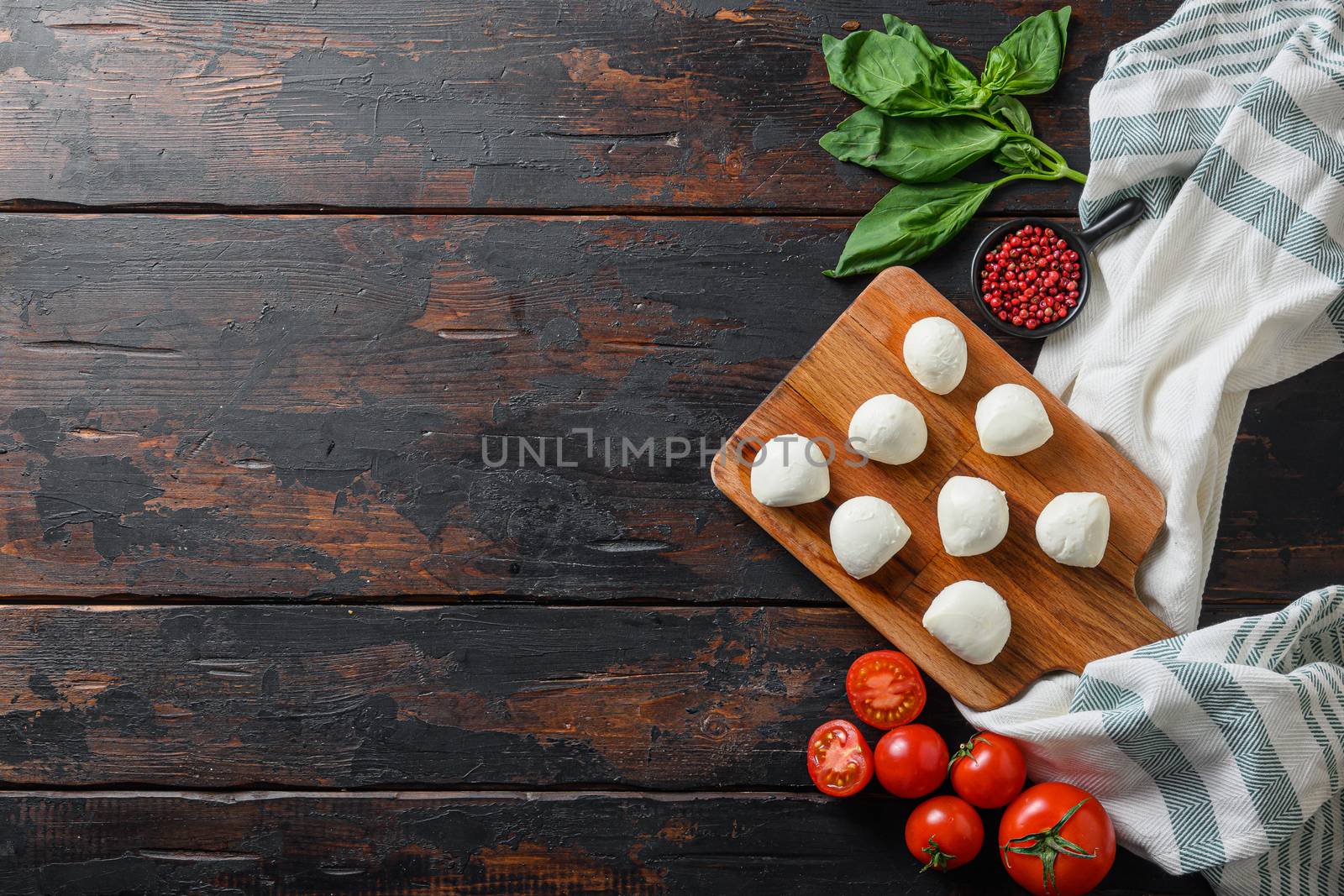Fresh cherry tomatoes, basil leaf, mozzarella cheese on old wood background table selective focus space for text by Ilianesolenyi