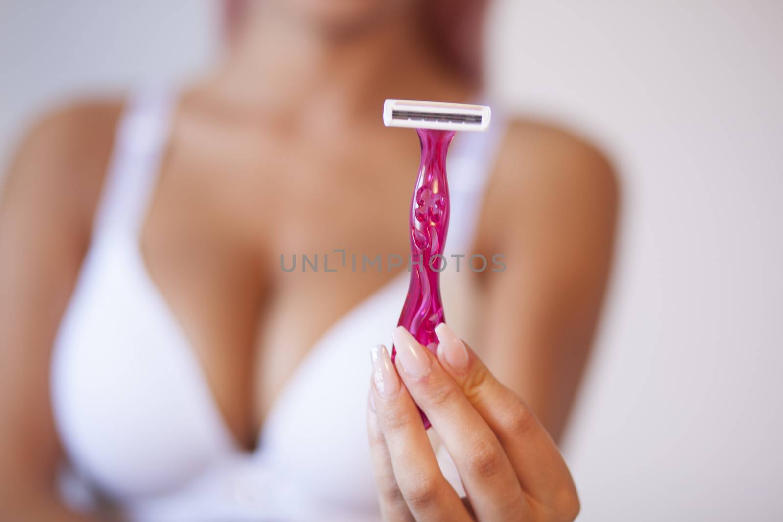 Pink hair attractive woman hold pink female shaver in hand by adamr