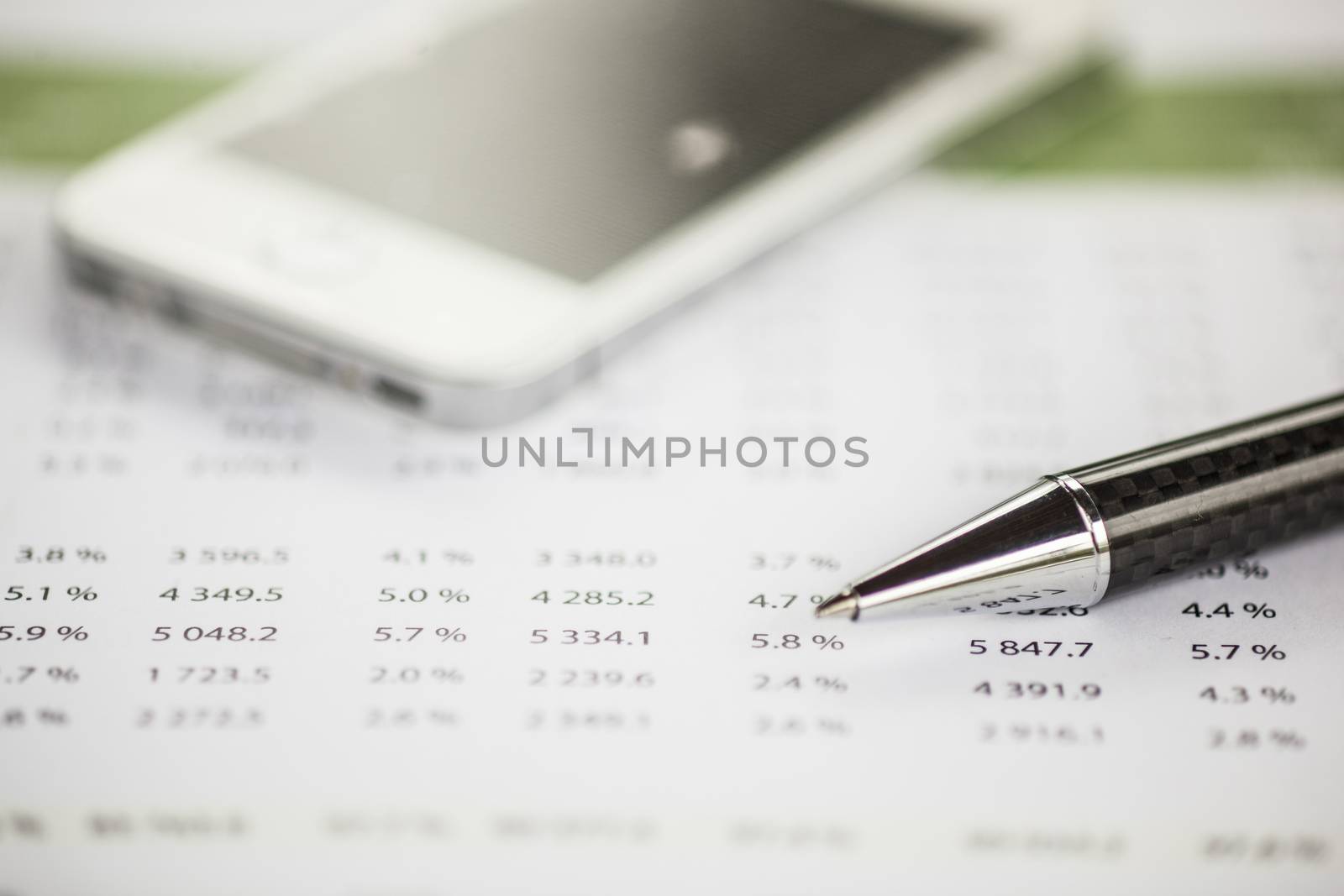 Business analysis - Accounting Calculating Cost Economic on office table. Pencil, chart on papper and bllured smartphone in background