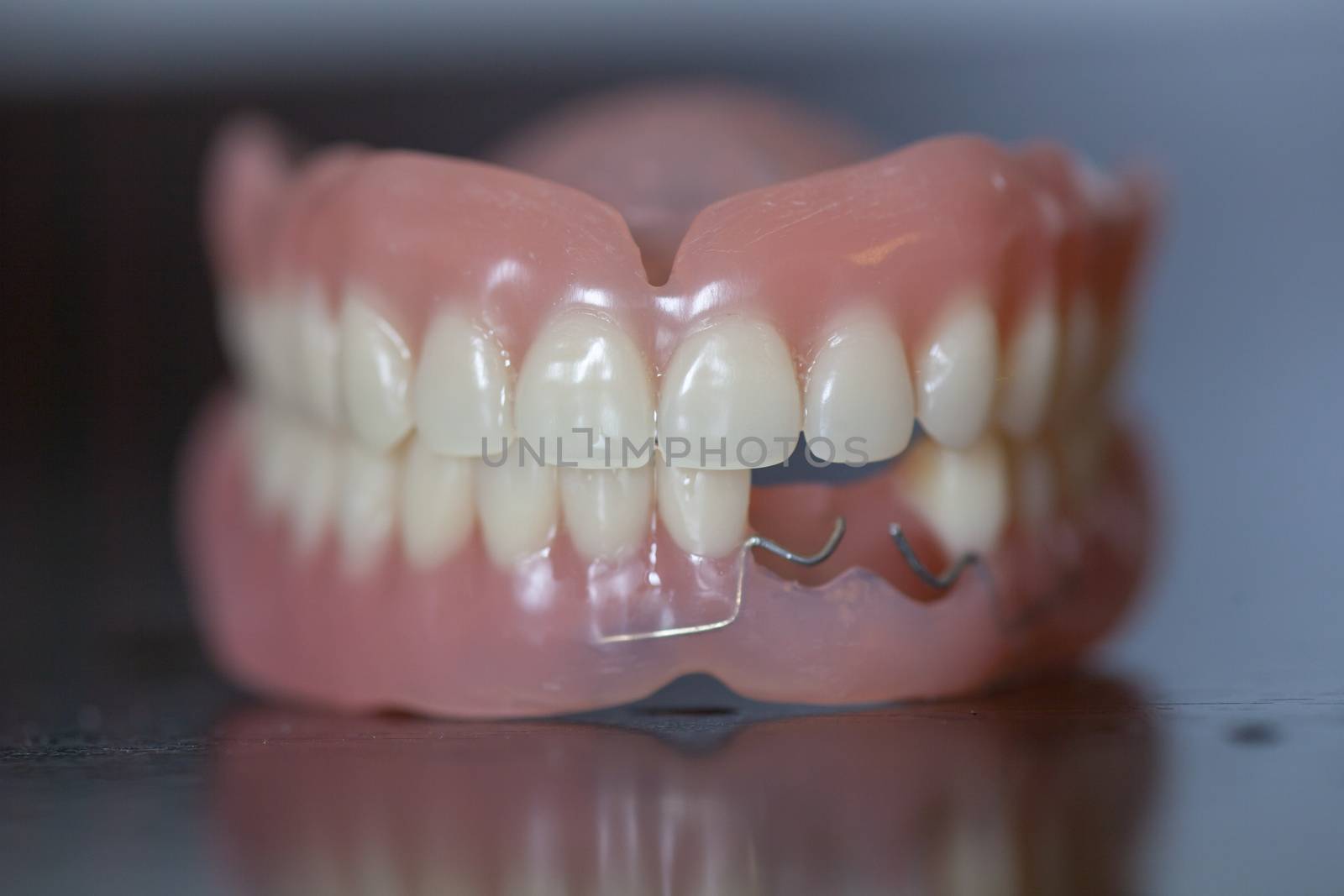 The artificial set of medical denture on dark table background