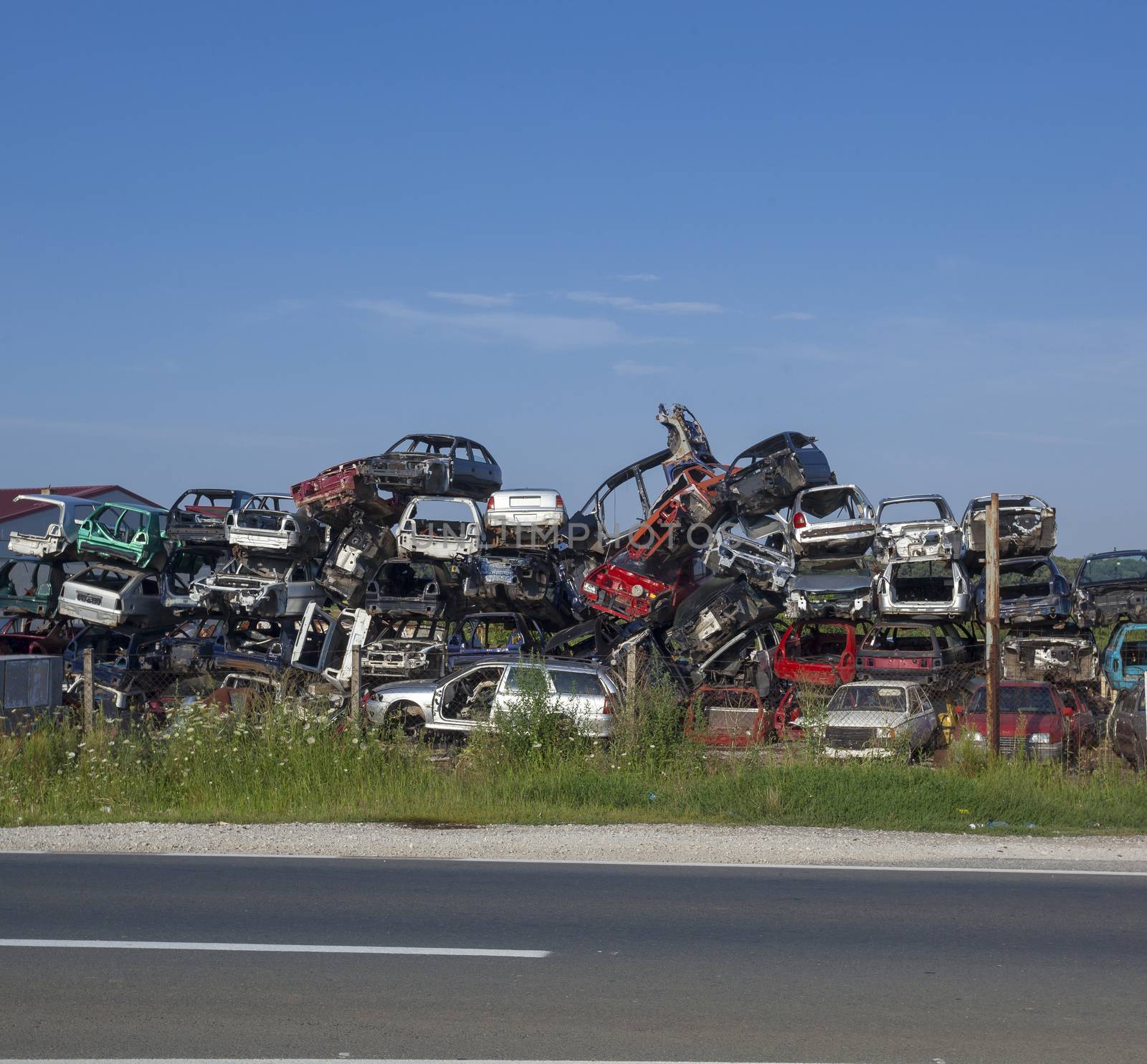 Old cars near road on junkyard are waiting for recycling