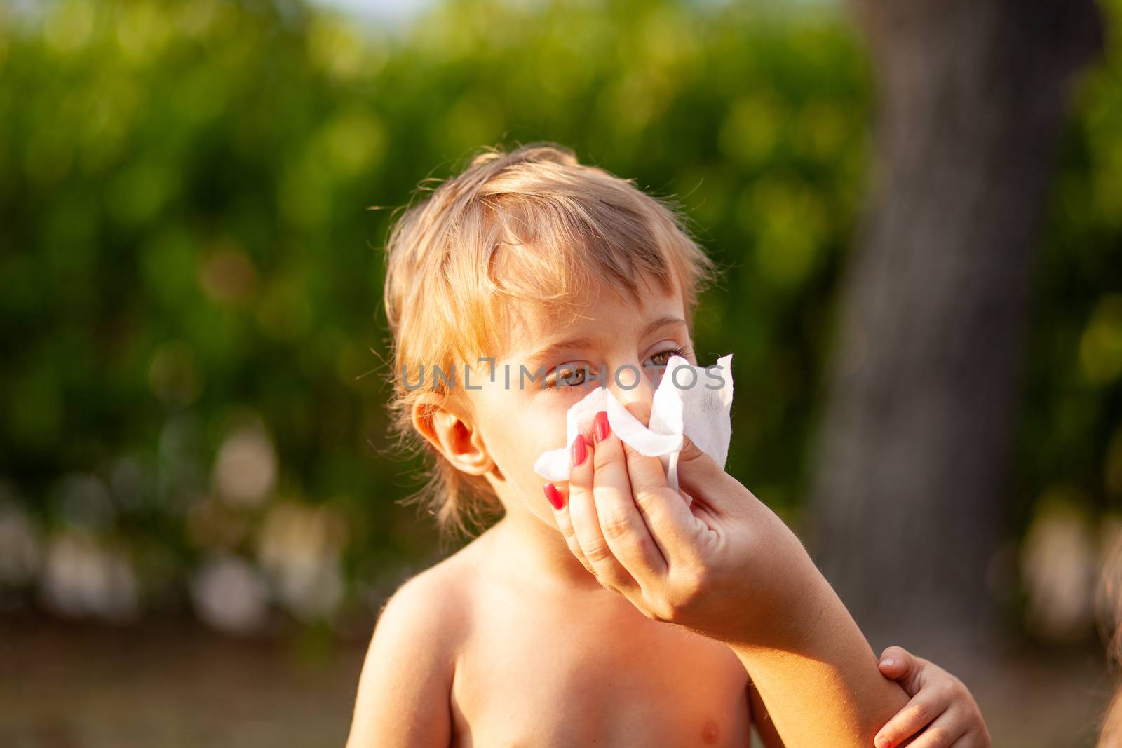 Hygiene - mom wiping the baby nose and face with wet wipes. Cleaning wipe, pure, clean, outdoor