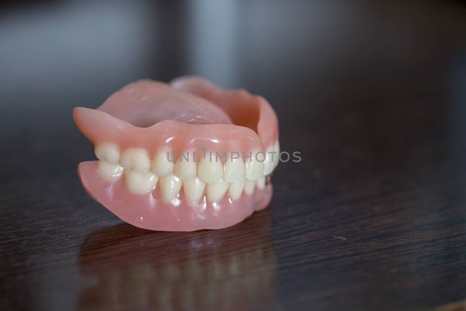 Full set of artificial medical denture on black background