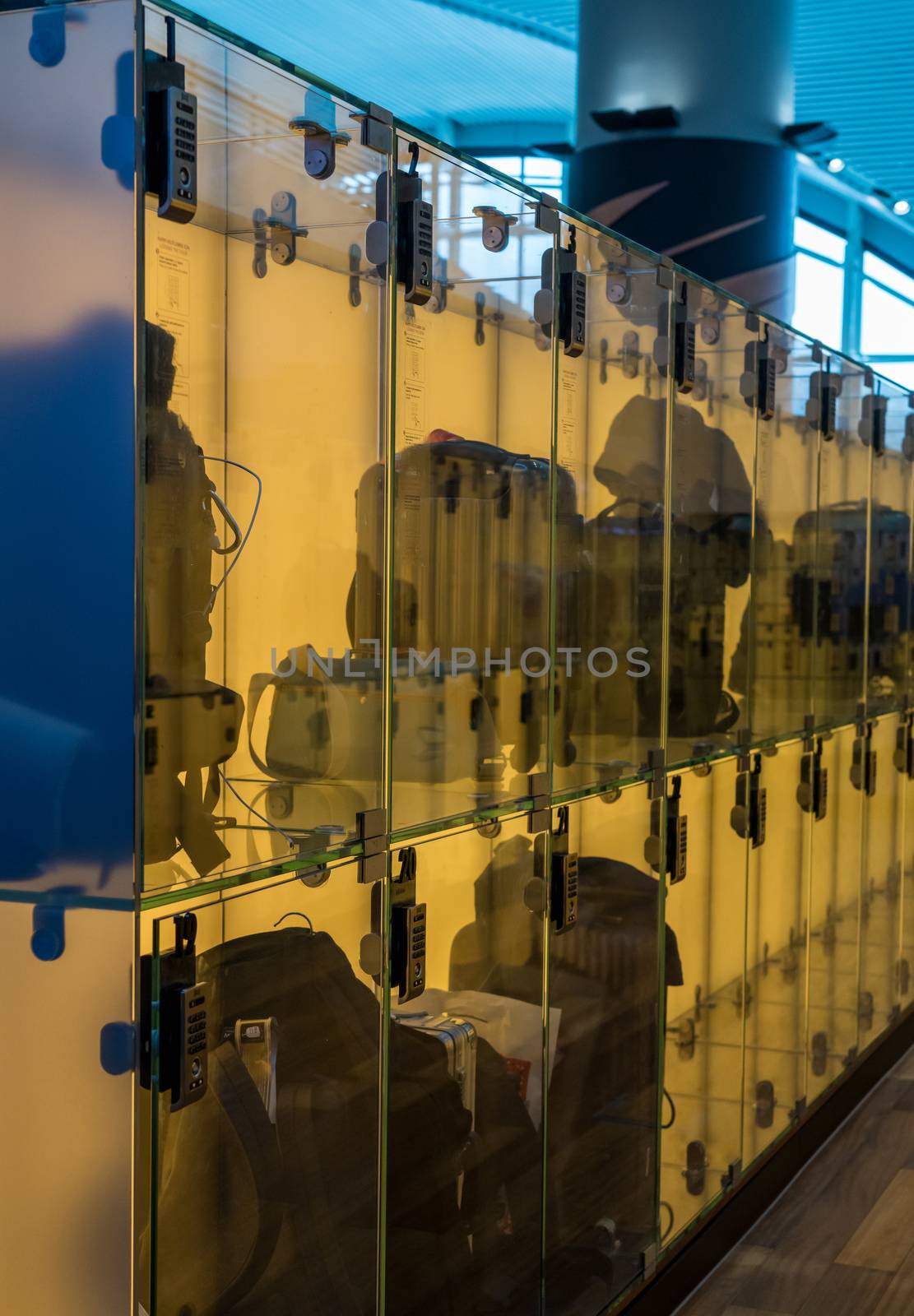 Luggage stored in transparent glass boxes in airport lounge by steheap