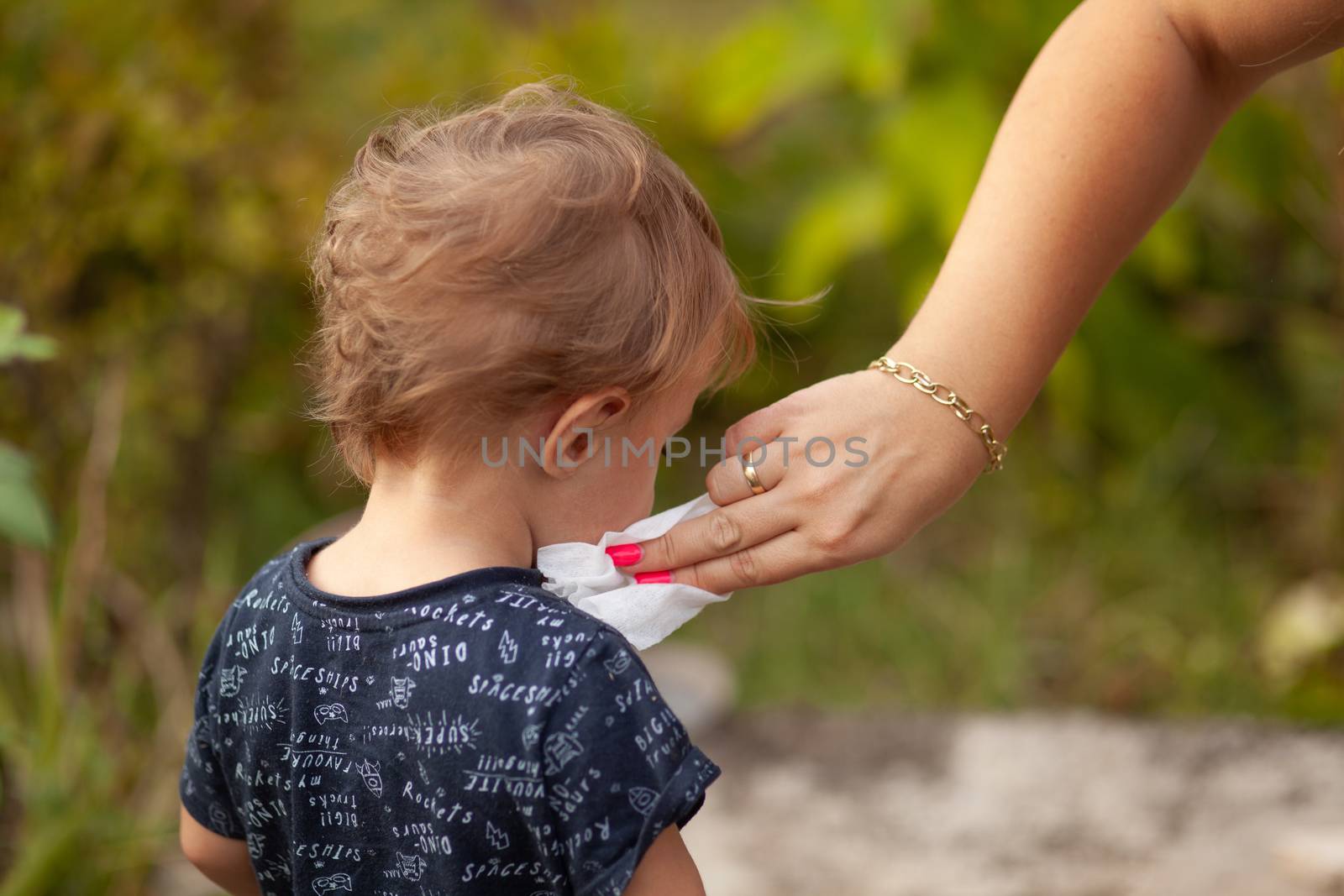 Hygiene - mom wiping the baby face skin with wet wipes. Cleaning wipe, pure, clean, outdoor