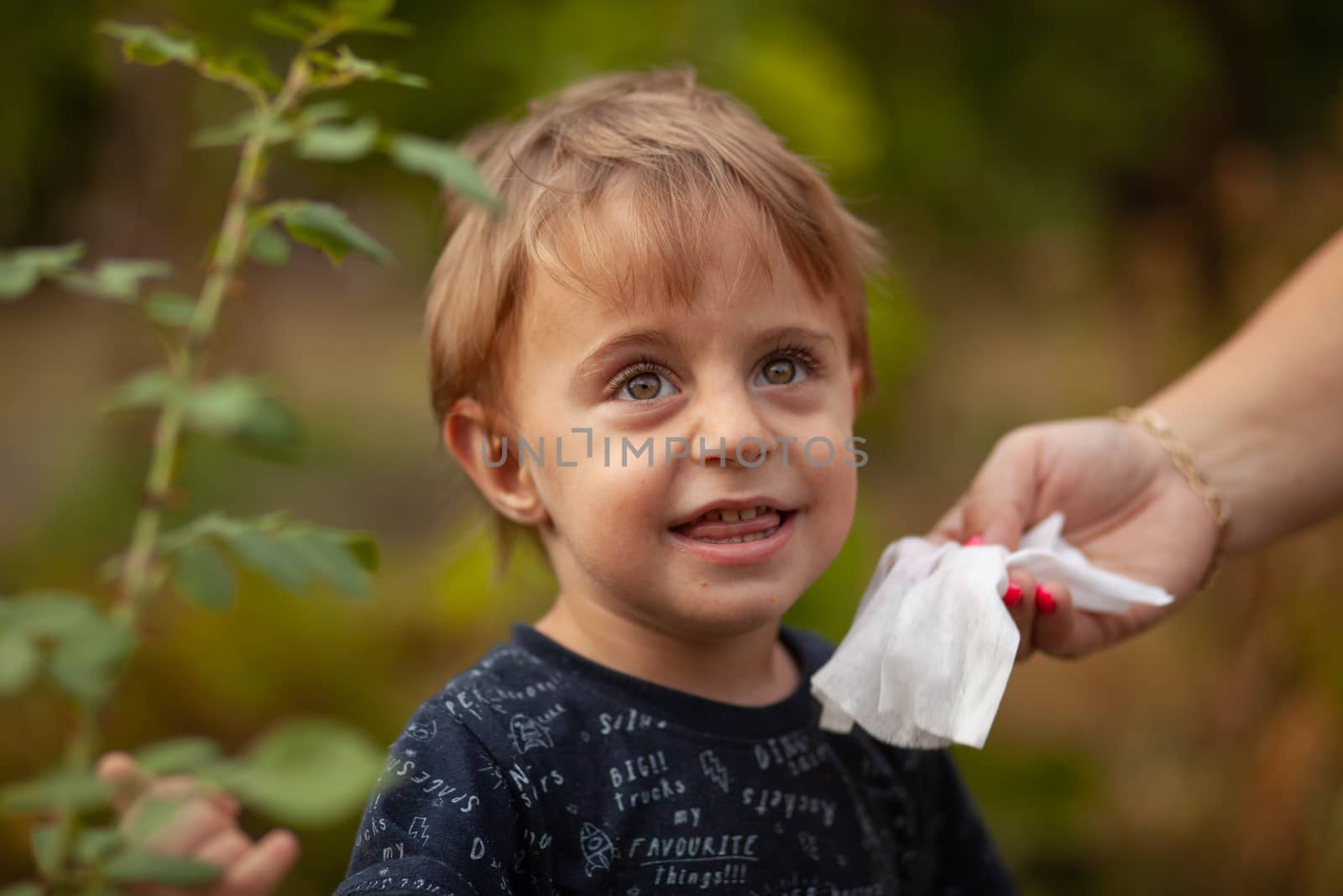 Hygiene - mom wiping the baby face skin with wet wipes. Cleaning wipe, pure, clean, outdoor