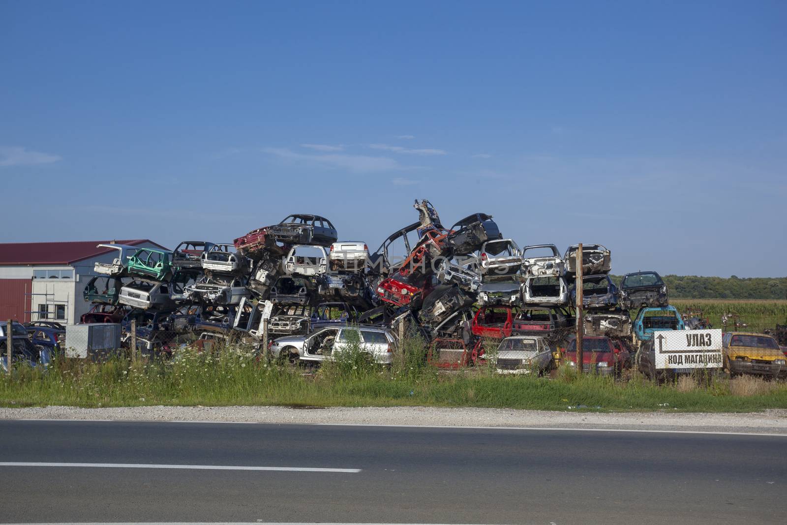 Old cars near road on junkyard are waiting for recycling