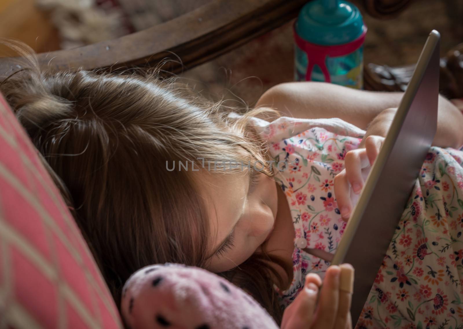 Young preschooler playing with a modern electronic tablet by steheap