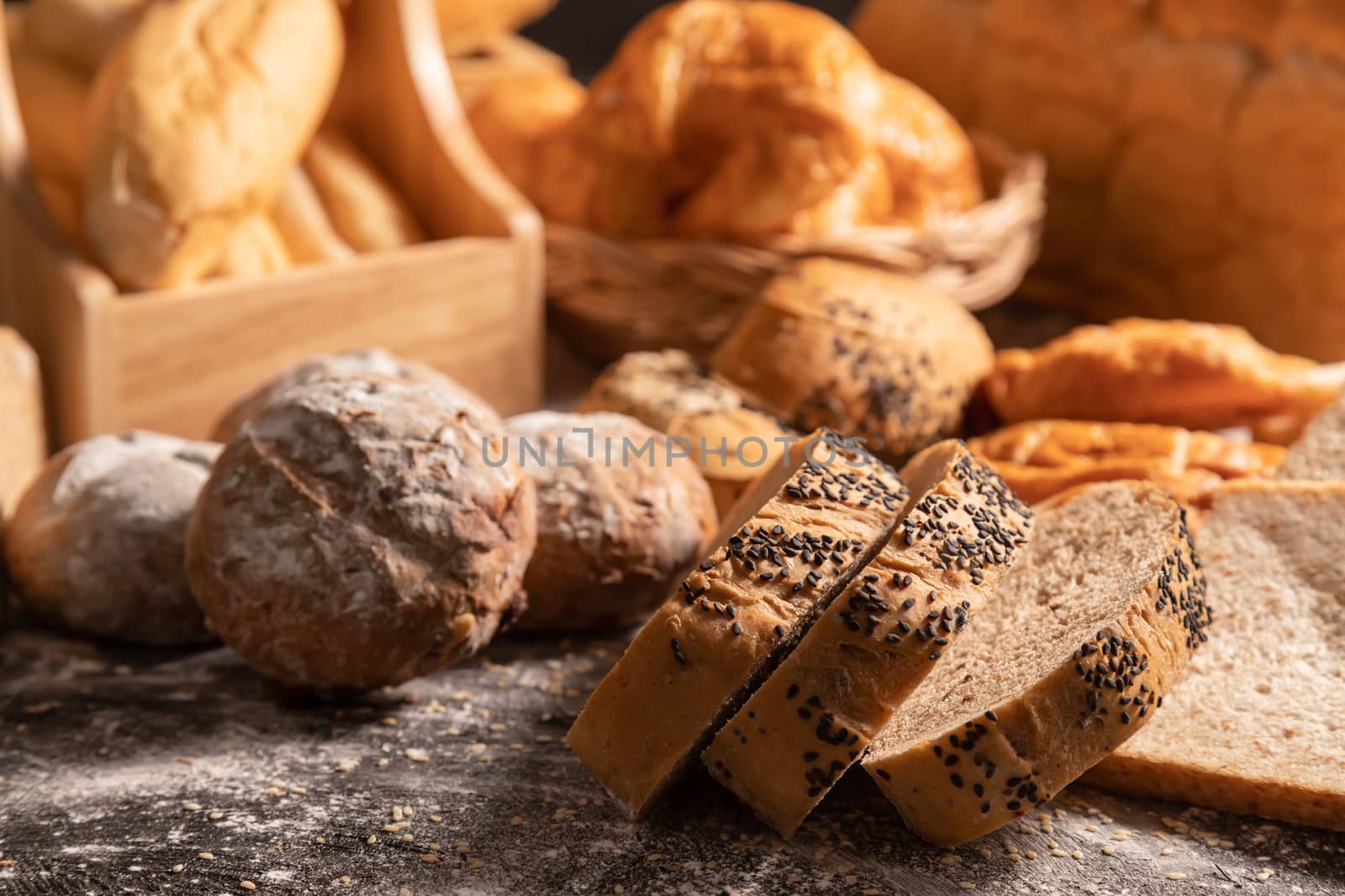 Close-up slice of sesame bread and variety of bakery on the table