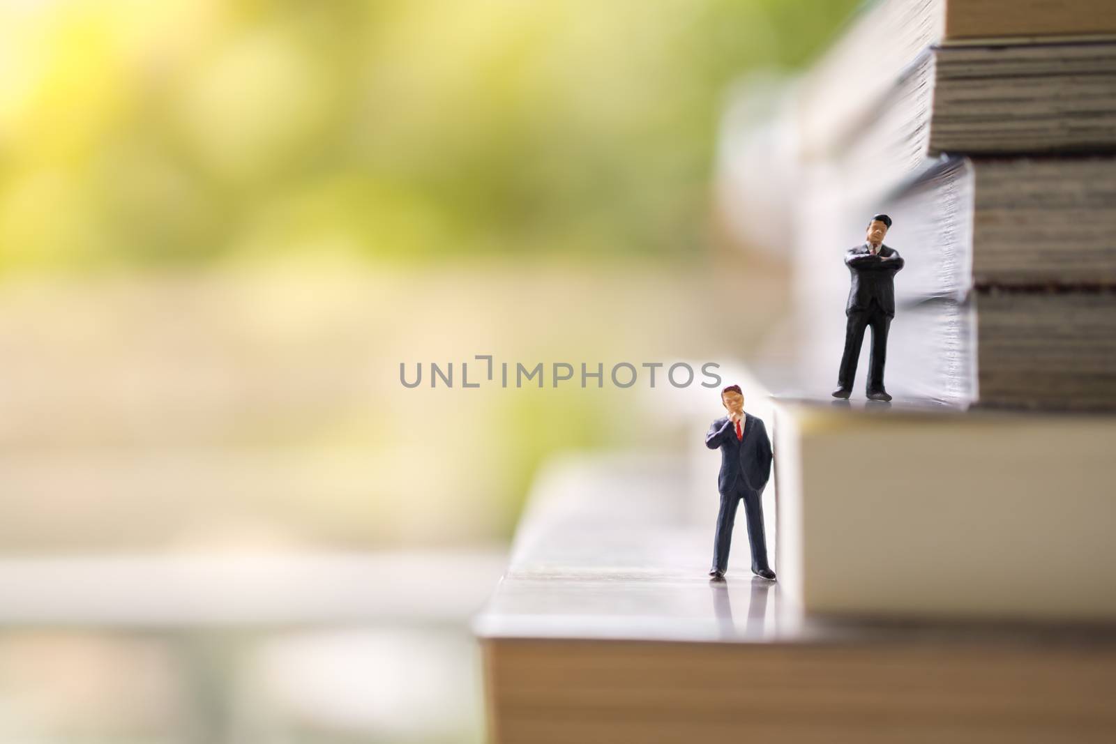 Business, Education, Knowleage and Planning Concept. Two businessman miniature figures people standing on stack of books with copy space.