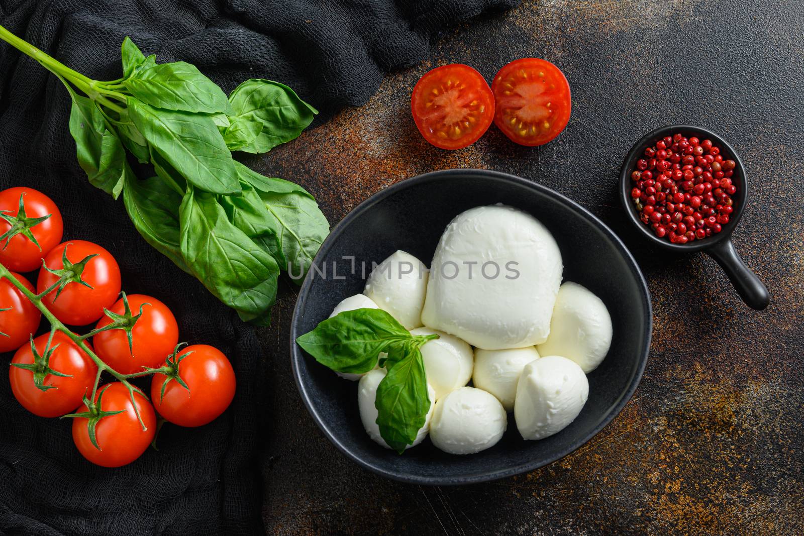 Mozzarella cheese, cherry tomatoes and basil leaves rose pepper on a dark rustic metal background, Italian cuisine ingredients for caprese salad top view. by Ilianesolenyi