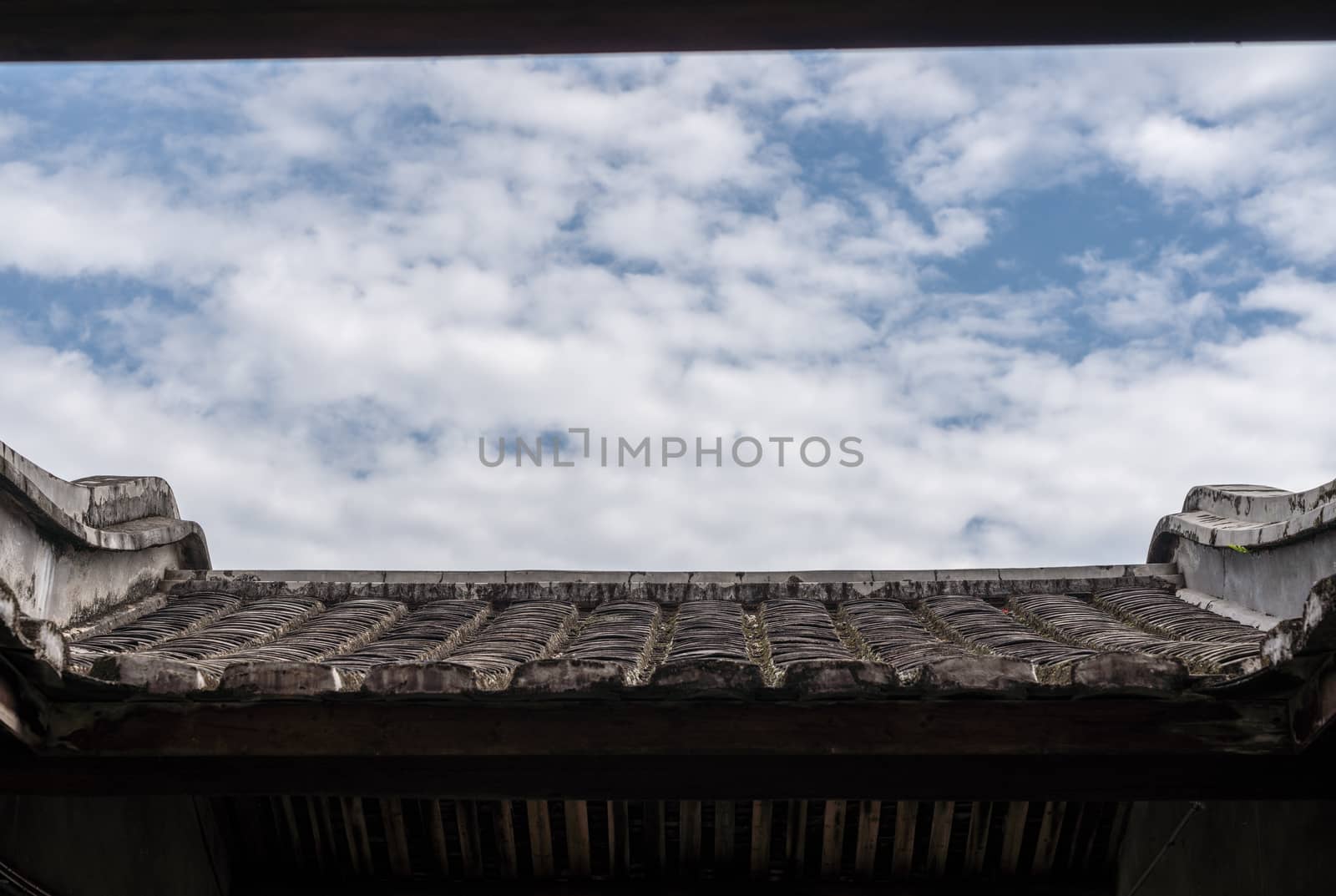 Blue sky above tiled roof of Tulou at Unesco heritage site near Xiamen
