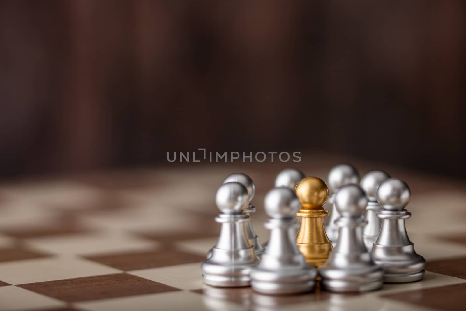 gold chessman standing in the midst on board with wooden background