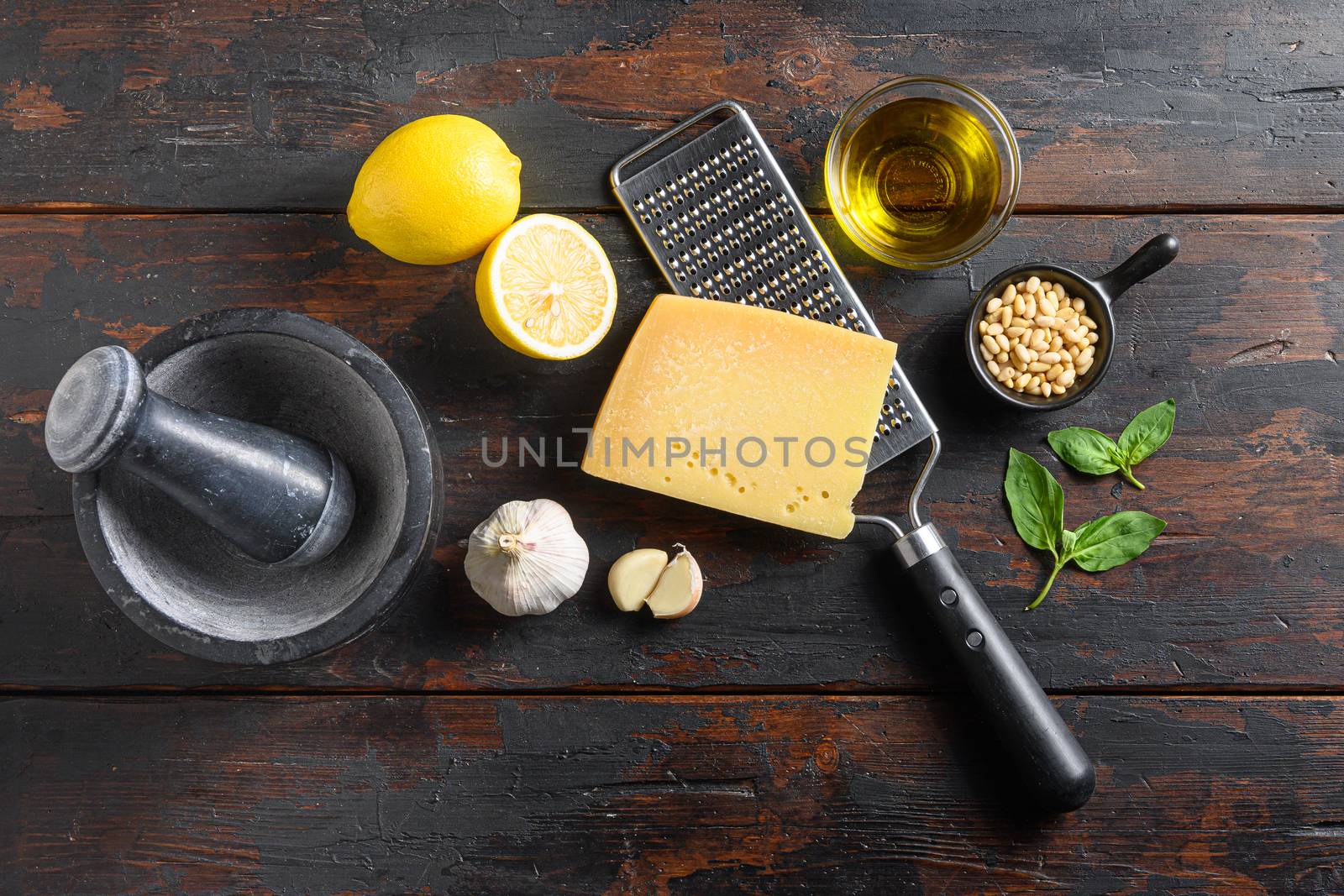 Italian food cooking ingredients for pesto sauce Basil, olive oil, parmesan, garlic, pine nuts. on dark rustic wooden table top view nobody by Ilianesolenyi