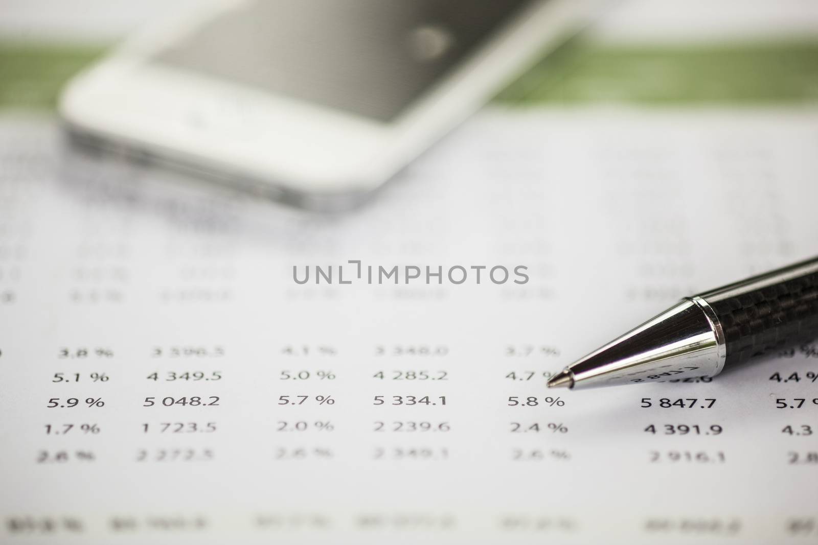 Business analysis - Accounting Calculating Cost Economic on office table. Pencil, chart on papper and bllured smartphone in background