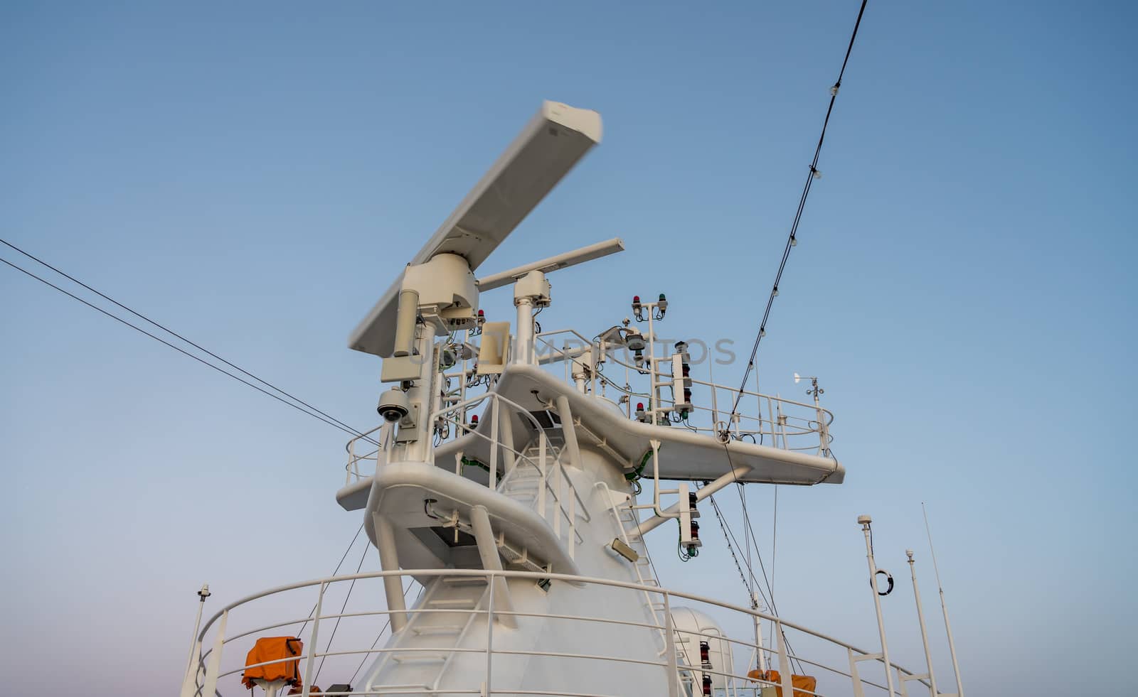 Navigation and radar equipment and antenna on the mast of cruise ship at dawn