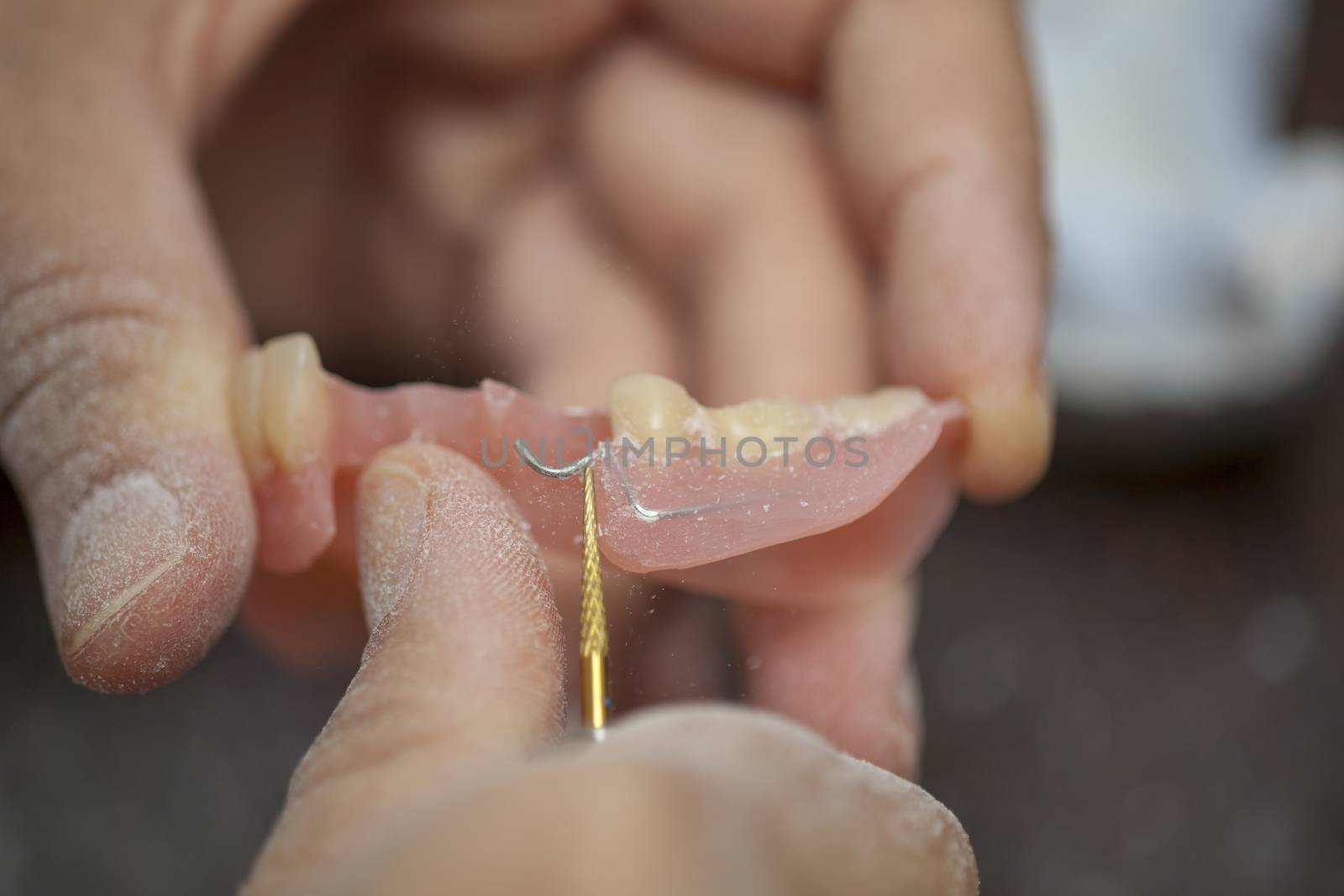 Dental technician work on denture prothesis in dental laboratory by adamr